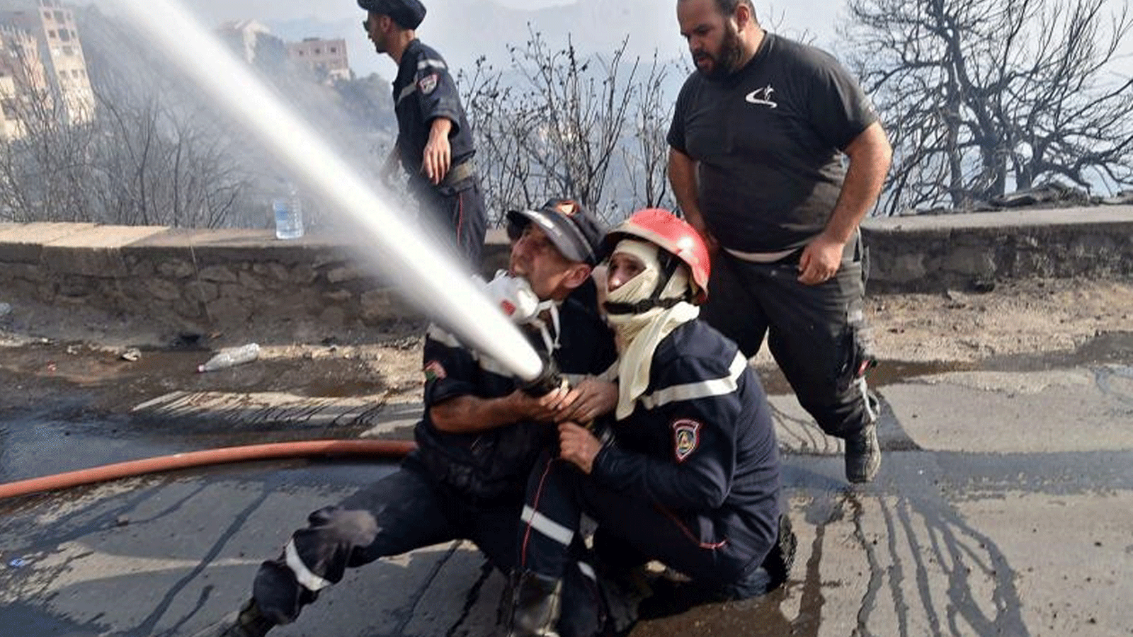 رجال الإطفاء يكافحون ألسنة اللهب في تلال الغابات بمنطقة القبائل، شرق العاصمة الجزائر. بتاريخ 11 آب/ أغسطس 2021.