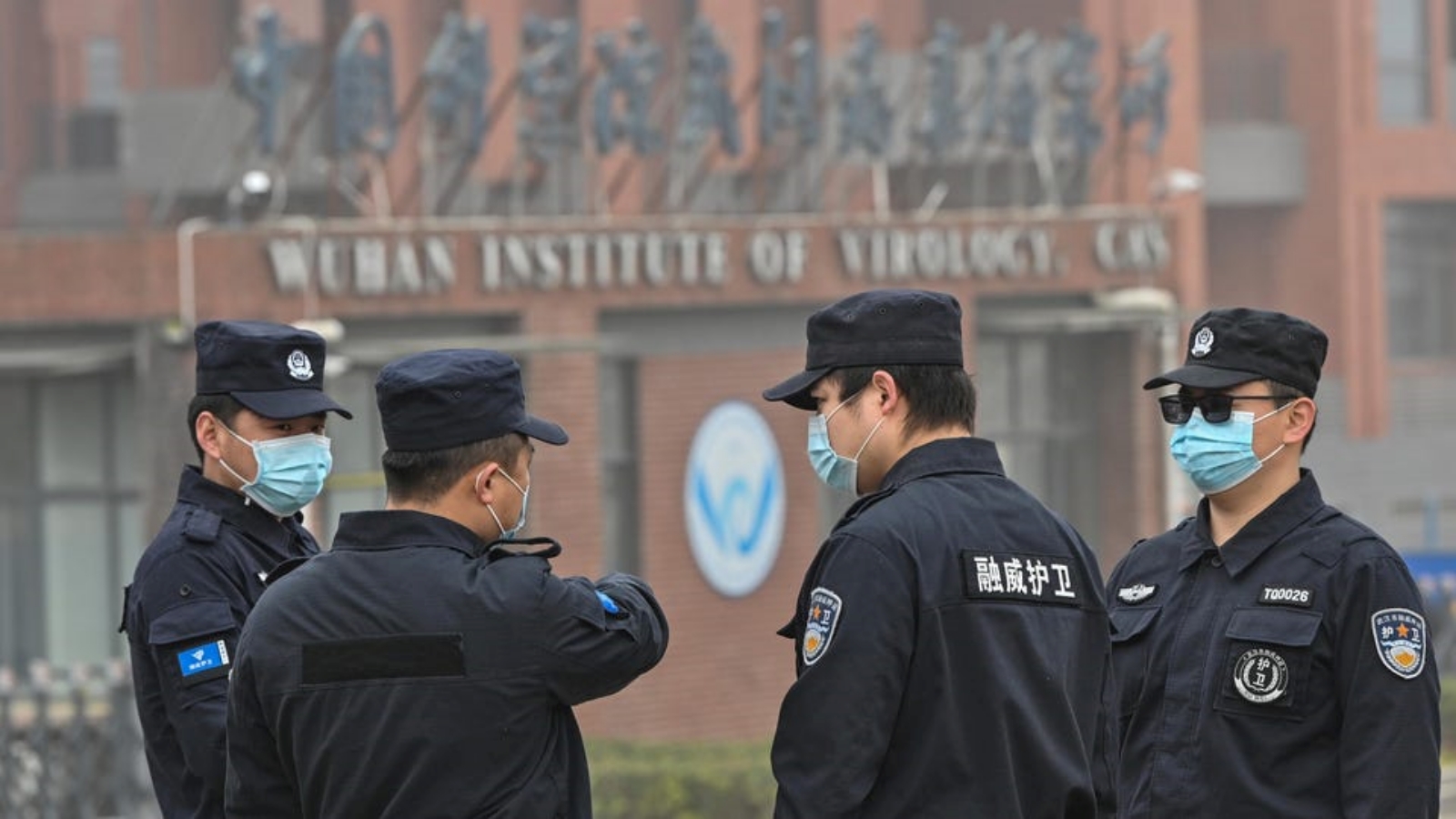 أفراد الأمن يقفون في حراسة معهد ووهان لعلم الفيروسات في الصين، بينما يقوم أعضاء فريق منظمة الصحة العالمية (WHO) بالتحقيق في أصول فيروس كورونا كوفيد-19