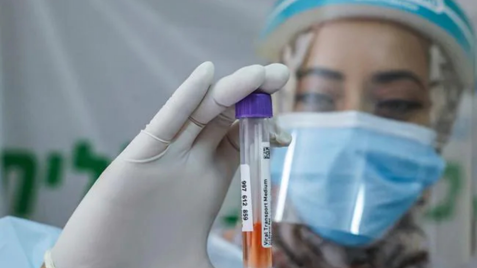 عاملة صحية تحمل عينة من لقاح كوفيد-19 ضمن دراسة لتطوير أدوية جديدة لمحاربة فيروس كورونا.