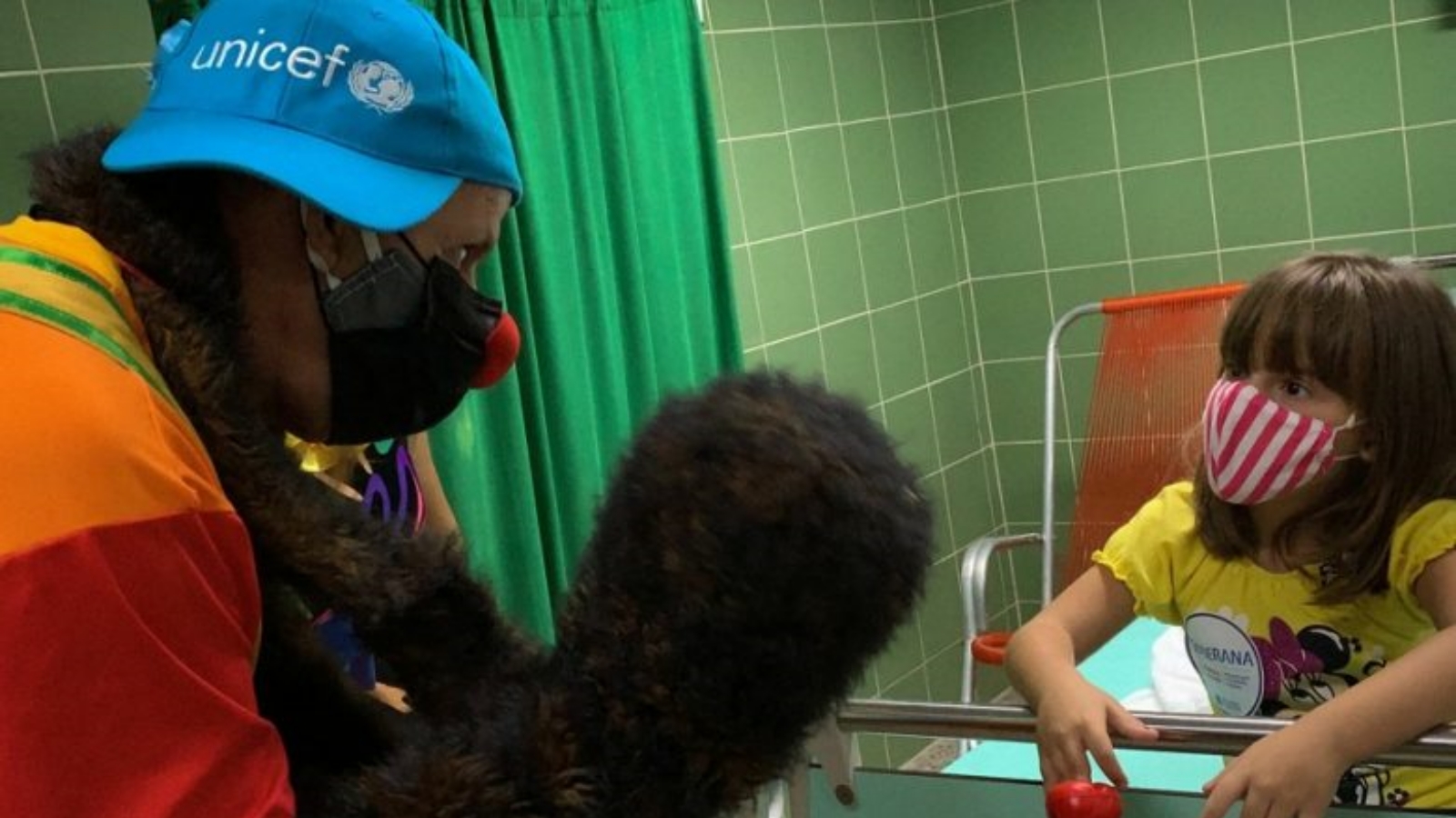زيارة المهرجين تجعل الانتظار أقل إيلامًا لأغاثا، وهي طفلة كوبية تبلغ من العمر سبع سنوات تلقت للتو الجرعة الثالثة والأخيرة من اللقاح الذي تختبره الجزيرة حاليًا لحماية الأطفال من COVID-19 أيضًا.