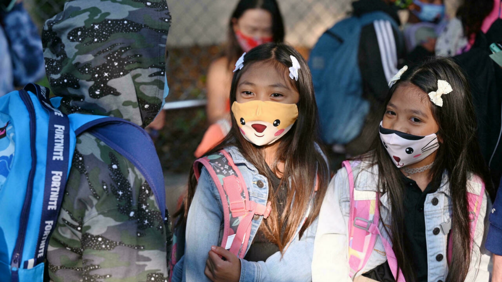 طلاب وأولياء الأمور يرتدون قناعات الوجه في اليوم الأول من العام الدراسي في مدرسة ابتدائية في لوس أنجلوس.