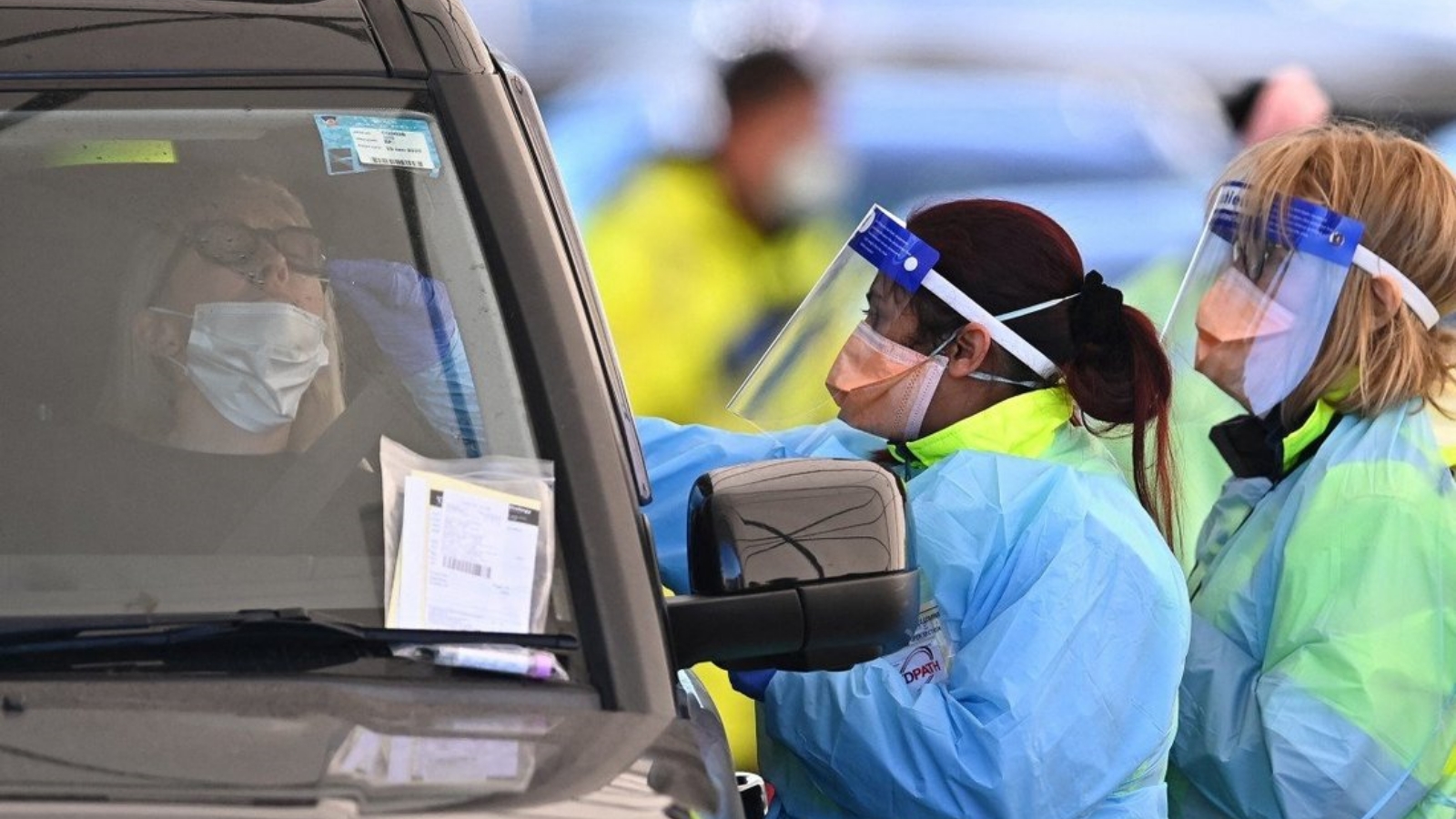 عاملون صحيون يأخذون عينات مسح لفيروس كورونا في مركز للاختبار بالسيارة في سيدني، مركز تفشي Covid-19 في أستراليا.
