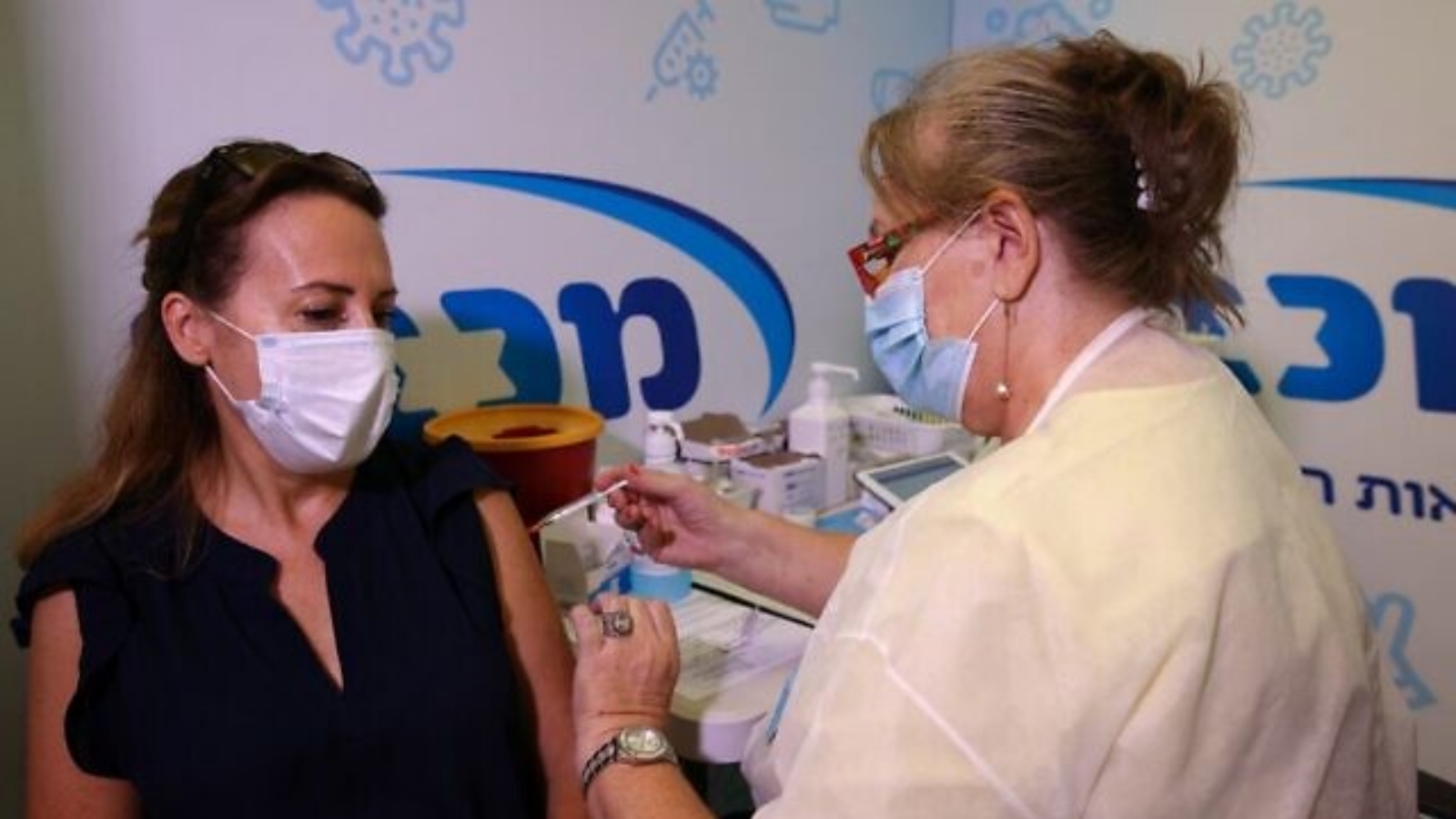 عاملة صحية إسرائيلية تعطي جرعة ثالثة من لقاح فايزر-بيونتيك كوفيد-19 لامرأة، في خدمة مكابي الصحية في بلدة ريشون لتسيون الإسرائيلية. بتاريخ 13 آب/أغسطس، 2021