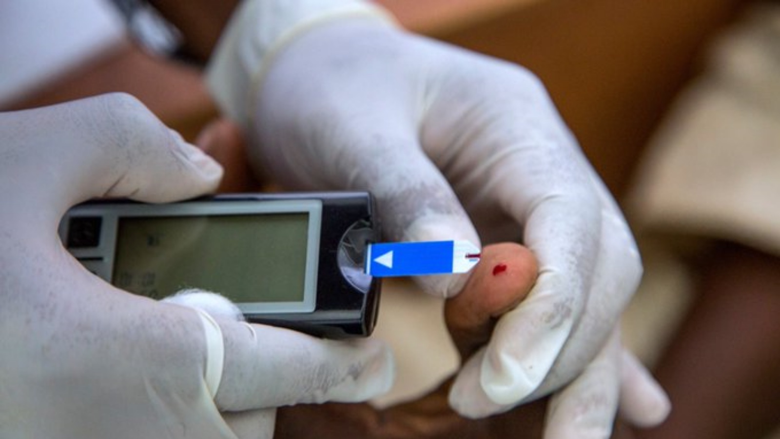 عامل صحي يأخذ عينة من دم مريض لقياس نسبة السكري. (من صفحة World Health Organization (WHO) في تويتر)