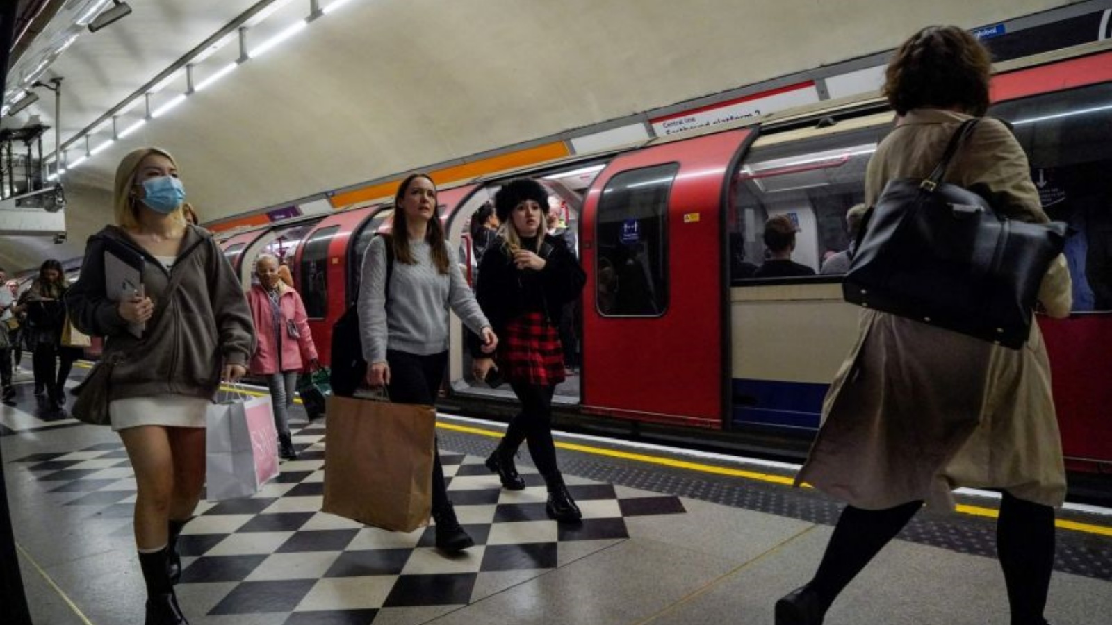 ركّاب، بعضهم يرتدون أقنعة، يمشون على طول رصيف بعد خروجهم من قطار أنفاق النقل إلى لندن في وسط لندن. في 19 تشرين الأول/أكتوبر 2021.