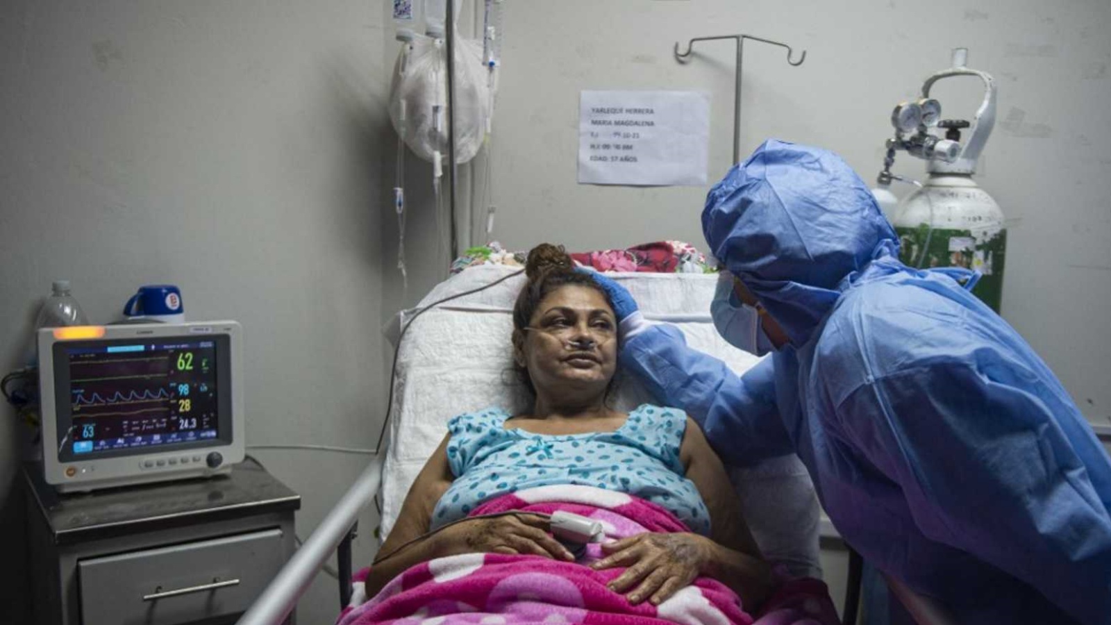 عاملة صحية تطمئن على مريضة كورونا كوفيد-19 في إحدى المستشفيات. (أرشيفية)