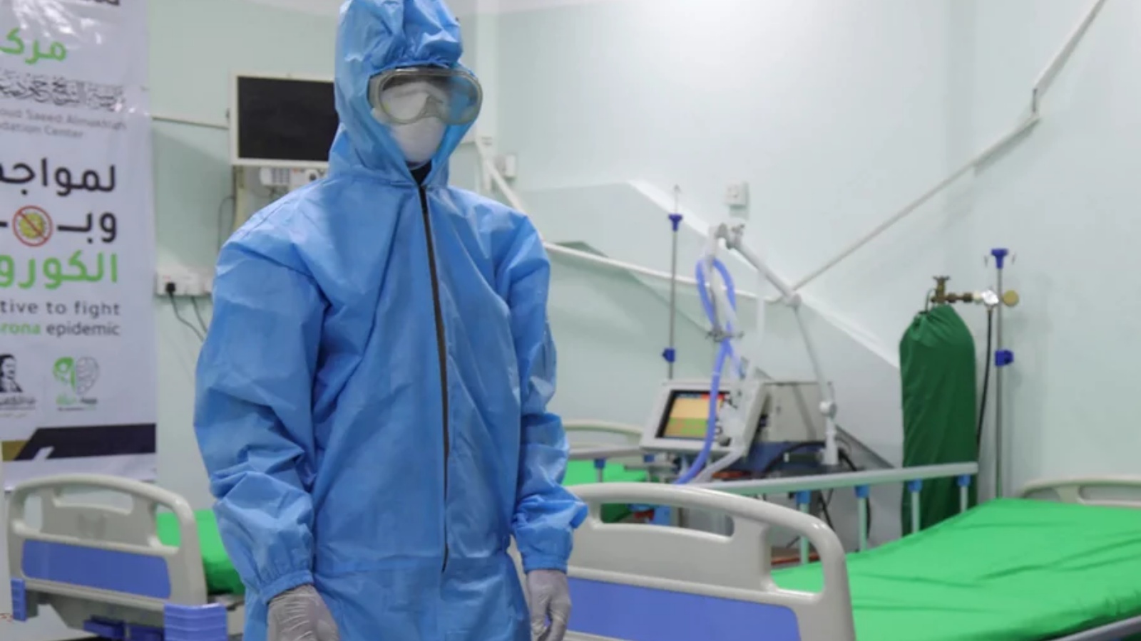 عامل صحي يرتدي معدات الوقاية الشخصية يقف في وحدة العناية المركزة لكوفيد-19 في إحدى المستشفيات.