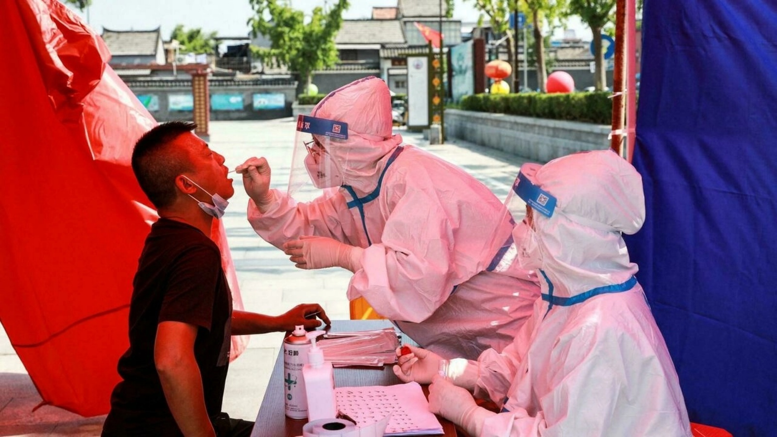 رجل يتلقى اختبار الحمض النووي لفيروس كورونا كوفيد-19 في هوايان بمقاطعة جيانغسو بشرق الصين، حيث تسابق الصين لاحتواء أسوأ تفشّي لفيروس كورونا منذ شهور. في 30 تموز/يوليو 2021.