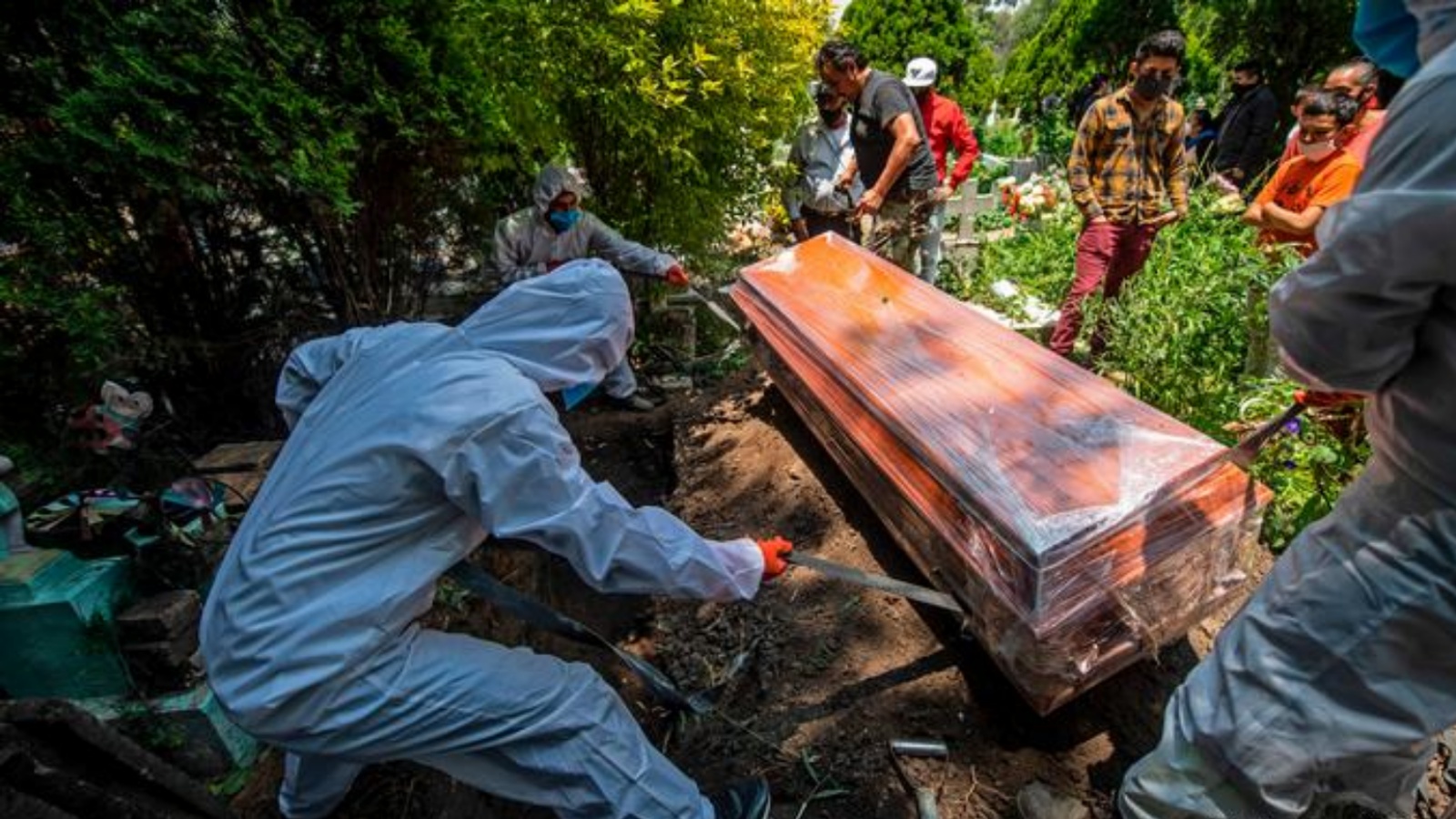 عمال يرتدون بدلات واقية أثناء دفن أحد ضحايا فيروس كورونا كوفيد 19 في المكسيك. (أرشيفية)
