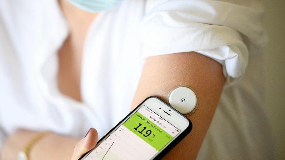 امرأة مصابة بالسكري تستخدم مقياسًا إلكترونيًا لقياس نسبة السكر في دمها