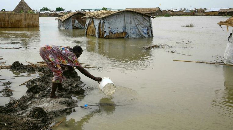 امرأة تبني سدًا من طين في مخيم للاجئين غمرته المياه في السودان في 15 سبتمبر 2021 