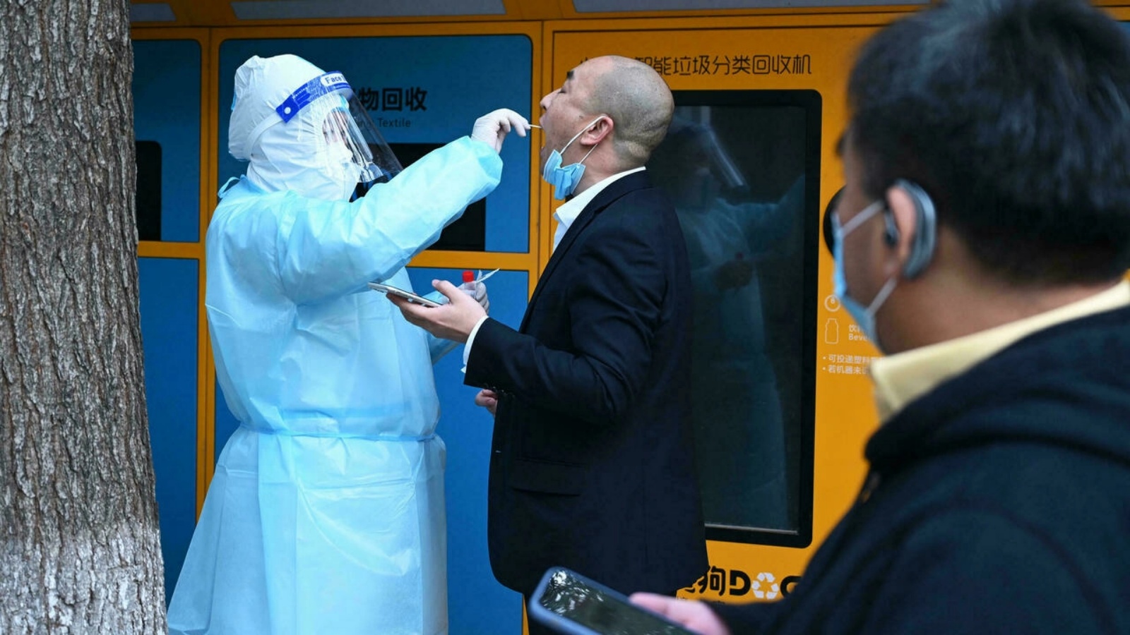 عامل صحة يأخذ عينة فيروس كورونا لأحد المارة في بكين. (أرشيفية)