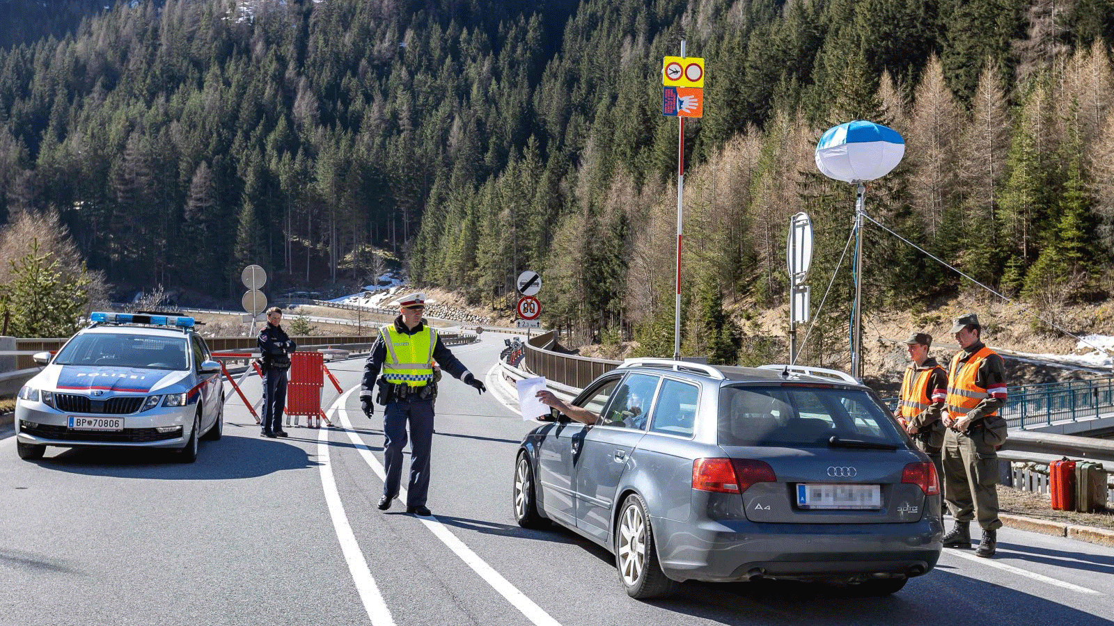 سائق يقدم وثائق لشرطي نمساوي على حاجز صحي في بلدة تيرول.في آذار/مارس 2020 في Soelden