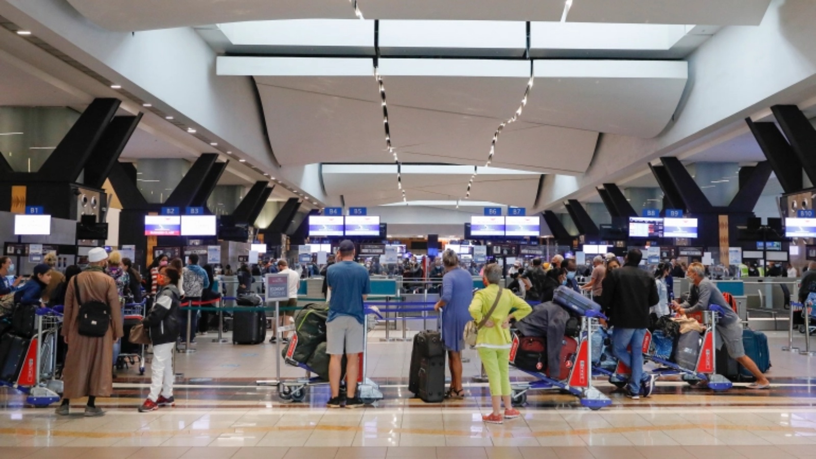 مسافرون يصطفون عند مكتب تسجيل الوصول في مطار أو آر تامبو الدولي في جوهانسبرج بعد أن حظرت عدة دول الرحلات الجوية من جنوب أفريقيا.