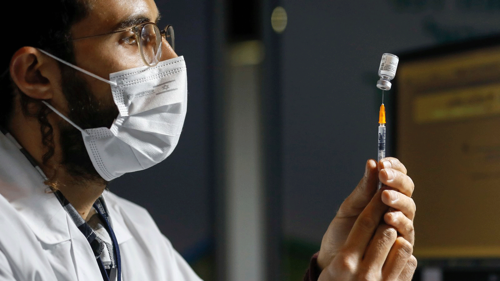 عامل رعاية صحية يحضر جرعة من لقاح COVID-19 في عيادة Kupat Holim Clalit في القدس.14 كانون الثاني/يناير2021