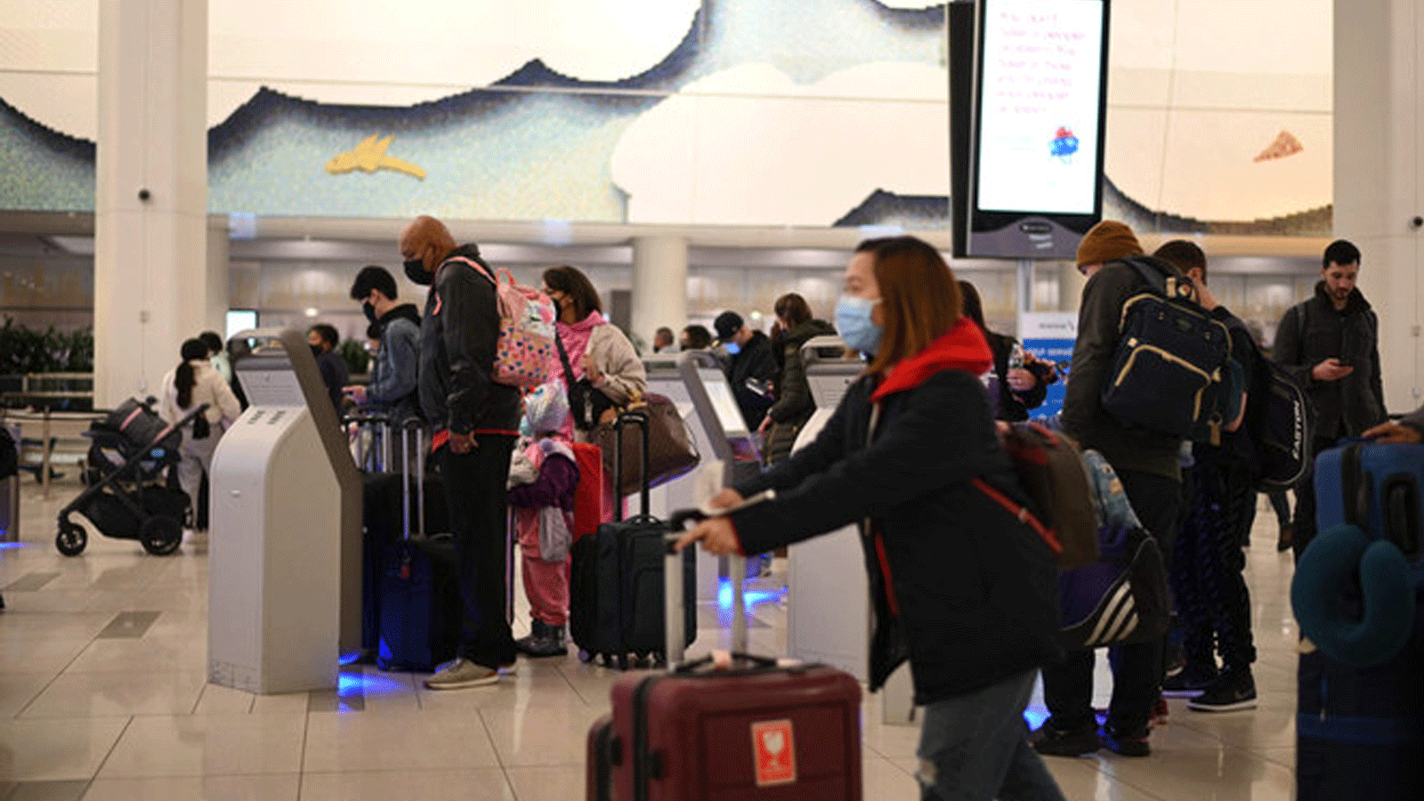  المسافرون يرتدون أقنعة في مطار LaGuardia الدولي في 30 تشرين الثاني/ نوفمبر 2021 في نيويورك مع تزايد القلق في جميع أنحاء العالم بشأن Omicron، أحدث متغير لـ Covid-19.