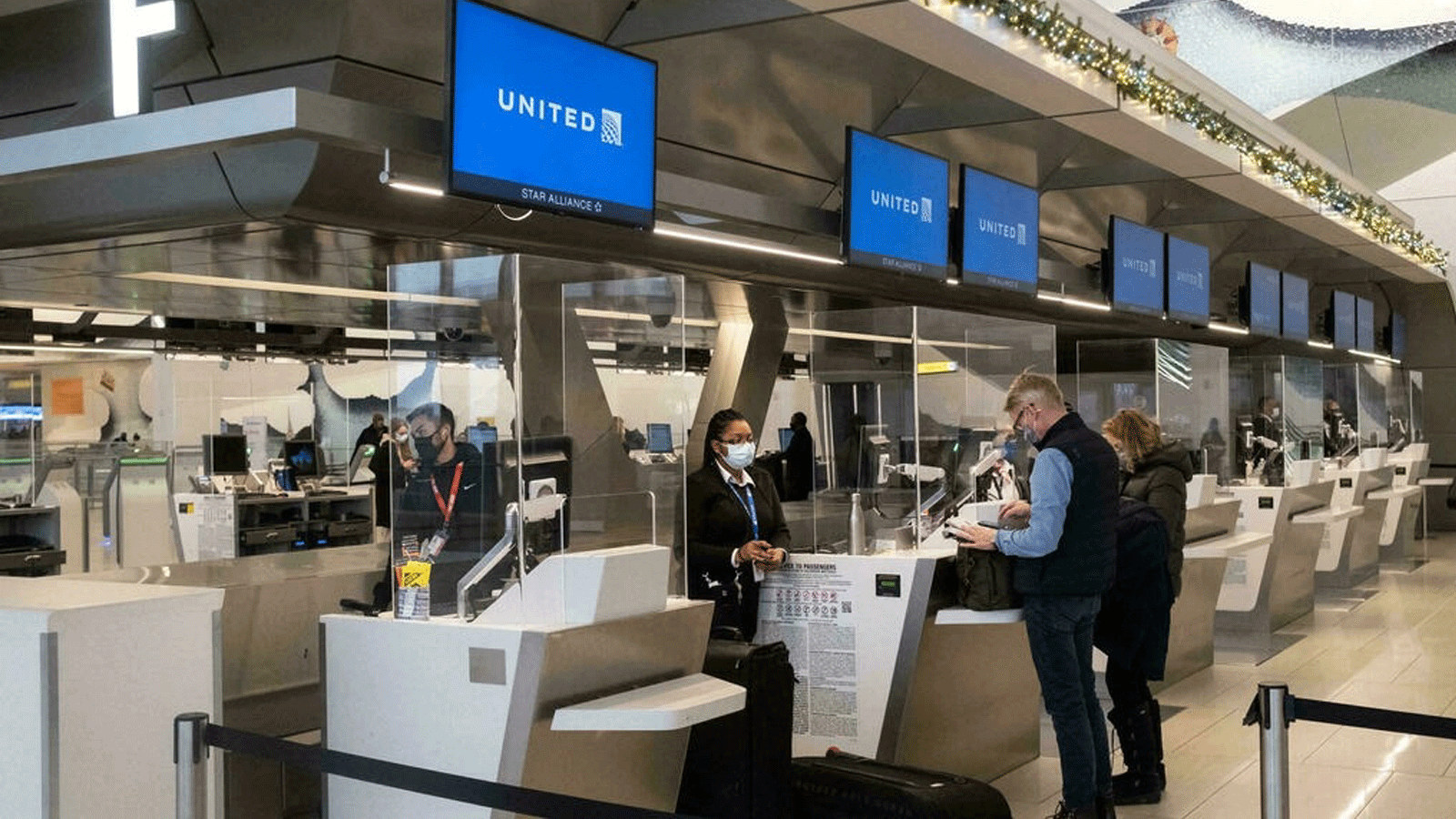 المسافرون يقومون بتسجيل الوصول في مطار LaGuardia بمدينة نيويورك في 24 كانون الأول/ ديسمبر 2021