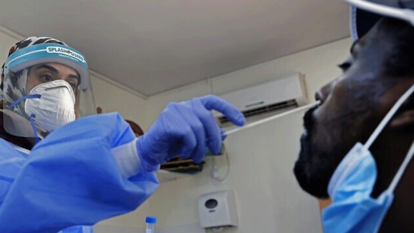 مسعف يجمع عينة من رجل في منشأة لفحص فيروس كورونا في أور يهودا. 22 تموز/يوليو 2020