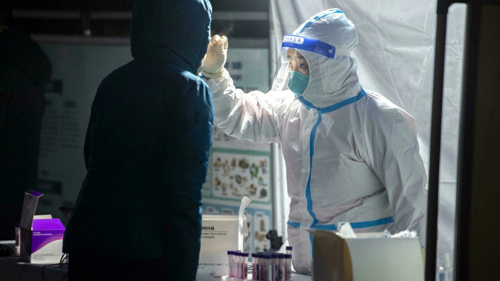 عامل صحة يأخذ عينة فيروس كورونا لأحد المرضى في بكين. (أرشيفية)