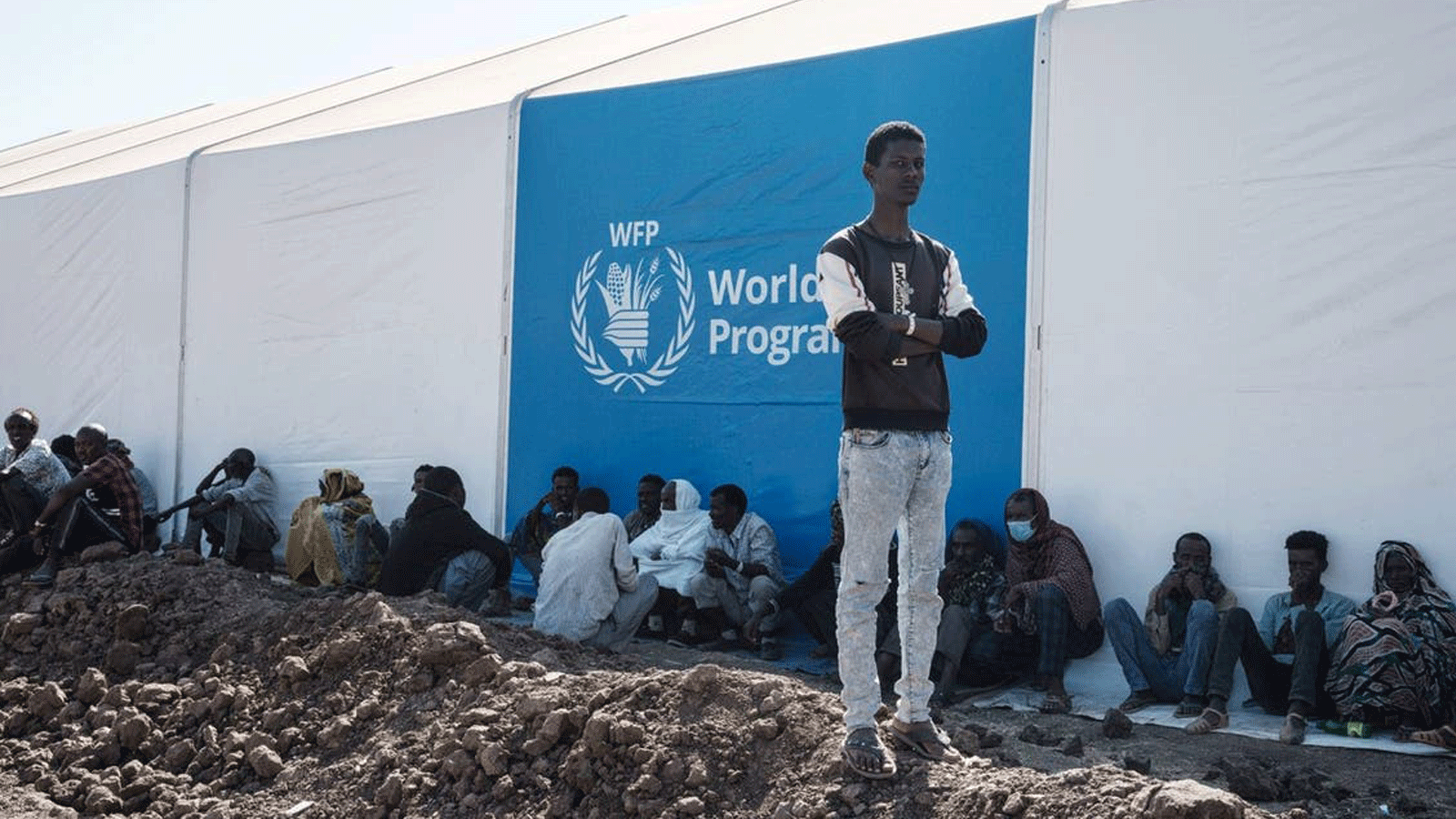 اللاجئون الإثيوبيون الذين فروا من صراع تيغراي الإثيوبي ينتظرون توزيع المساعدات بجوار مستودع أقامه برنامج الأغذية العالمي في مخيم أم ركوبة للاجئين في القضارف، شرق السودان. 6 ديسمبر / كانون الأول 2020.
