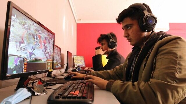 شبان يلعبون لعبة الحرب على أجهزة الحاسوب