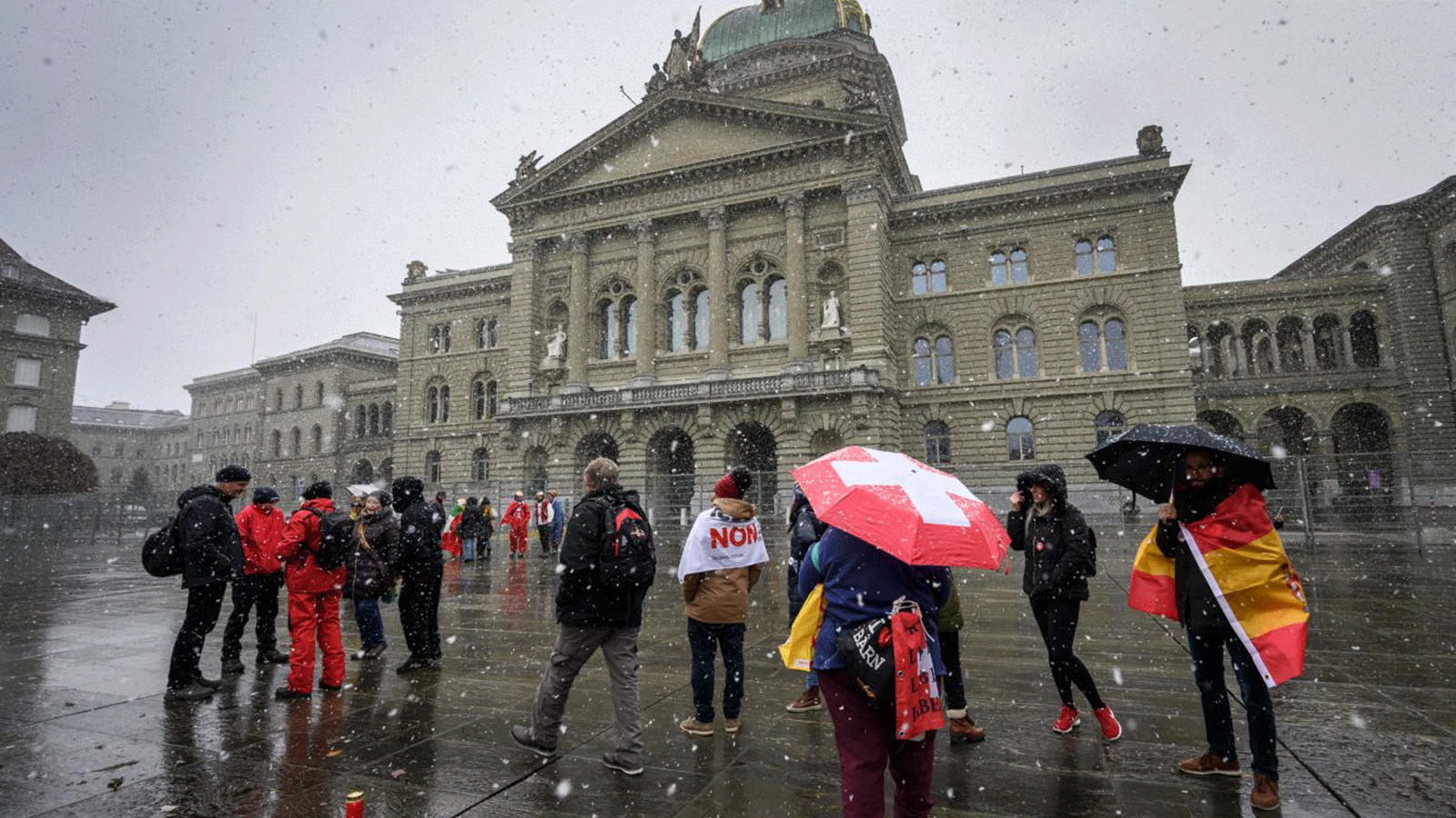متظاهرون ضد الإجراءات لمواجهة انتشار فيروس كورونا تحت الثلوج أمام البرلمان السويسري. تشرين الثاني/نوفمبر 2021