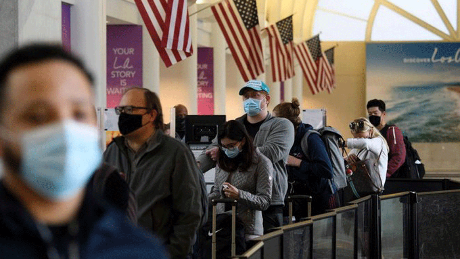 ركاب ينتظرون في طابور لدخول نقطة تفتيش تابعة لإدارة أمن النقل في مطار لوس أنجلوس الدولي قبل عطلة عيد الشكر في لوس أنجلوس، كاليفورنيا، 25 تشرين الثاني/ نوفمبر2020.