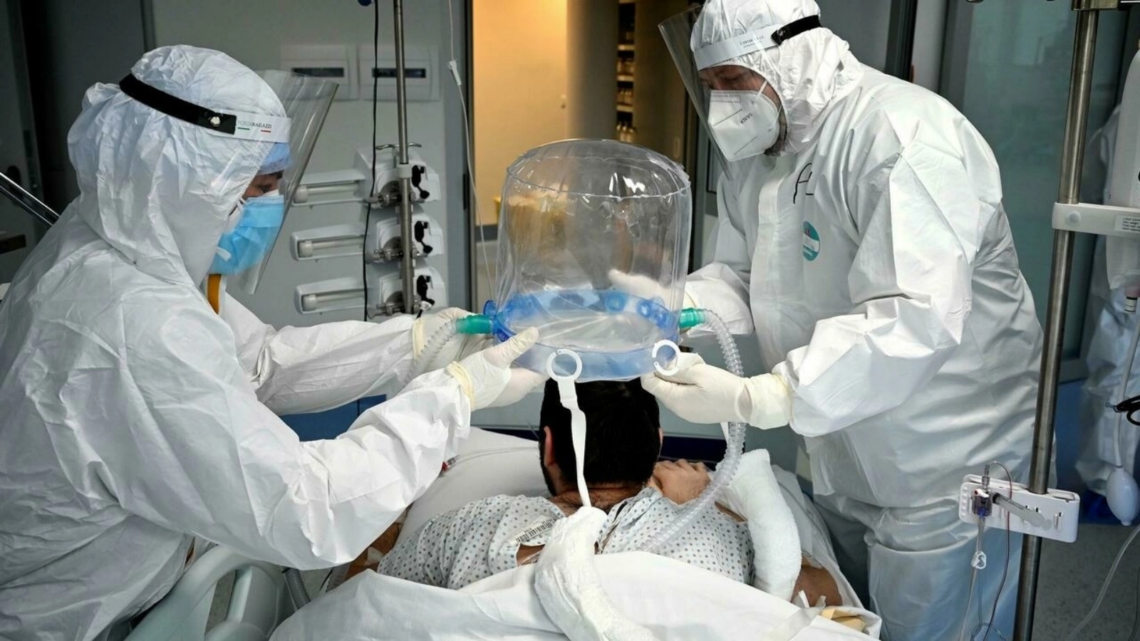 عمال صحة يعاينون مريضاً في وحدة العناية التابعة لكورونا كوفيد-19