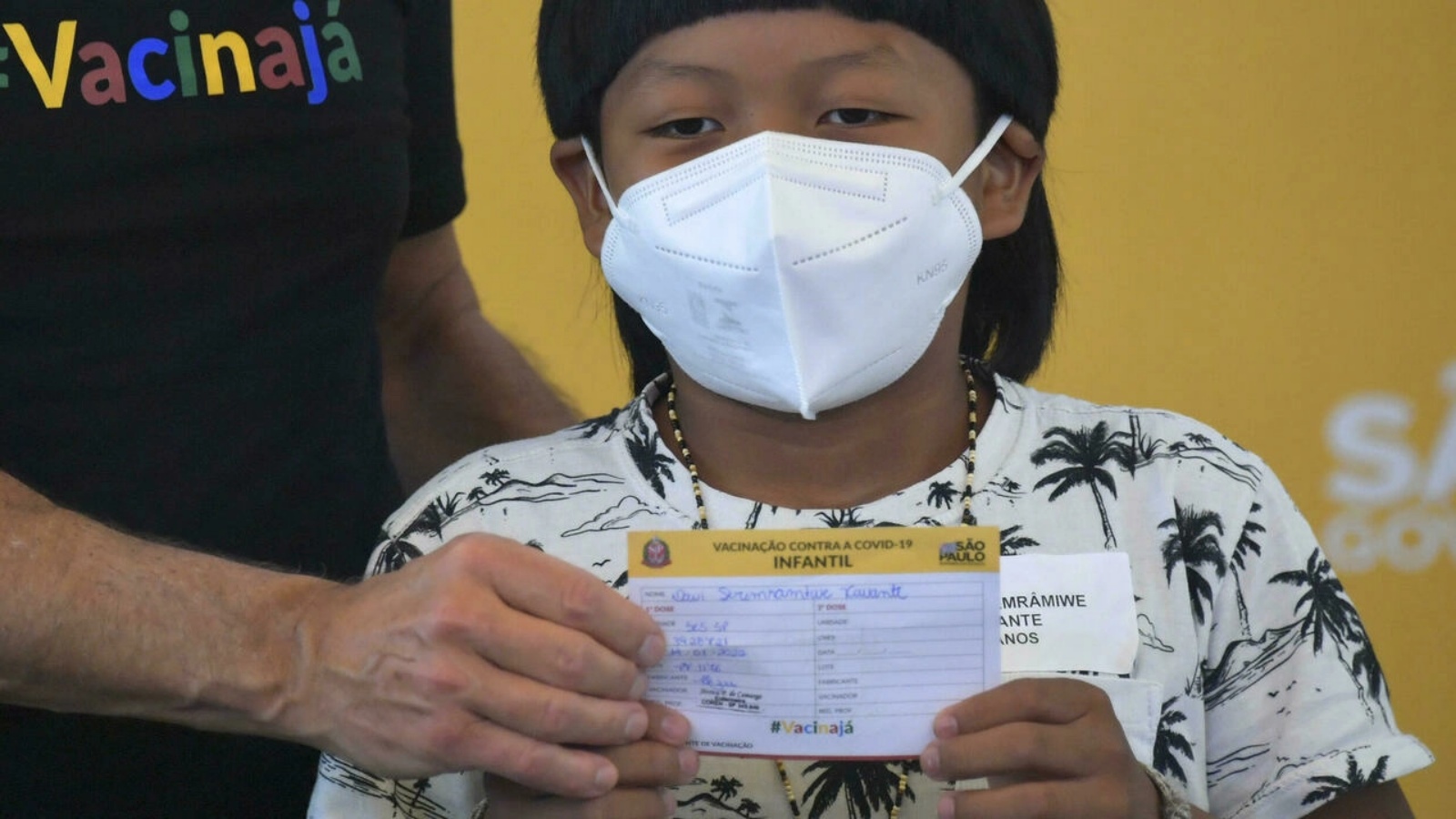 دافي سيريمراميوي زافانتي، وهو من السكان الأصليين يبلغ من العمر ثماني سنوات ويعاني إعاقة، أول طفل برازيلي يتلقى اللقاح خلال حفل رسمي في مستشفى عيادات ساو باولو في 14 كانون الثاني/يناير 2022