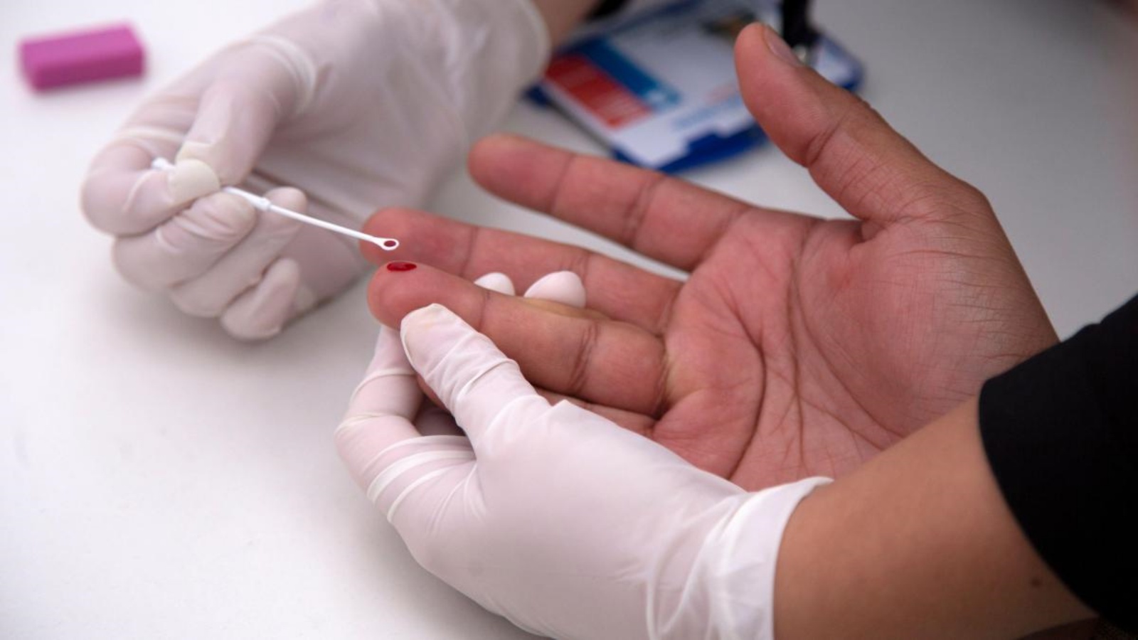 عاملة صحة تأخذ عينة دم من مريض سرطان (توضيحية)