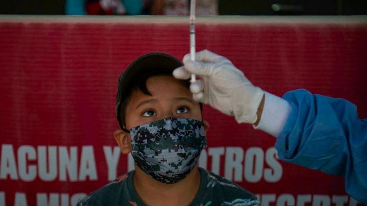 عامل صحة يستعد لحقن طفل بلقاح فايزر/بايونتك في ليما، في 25 يناير 2022