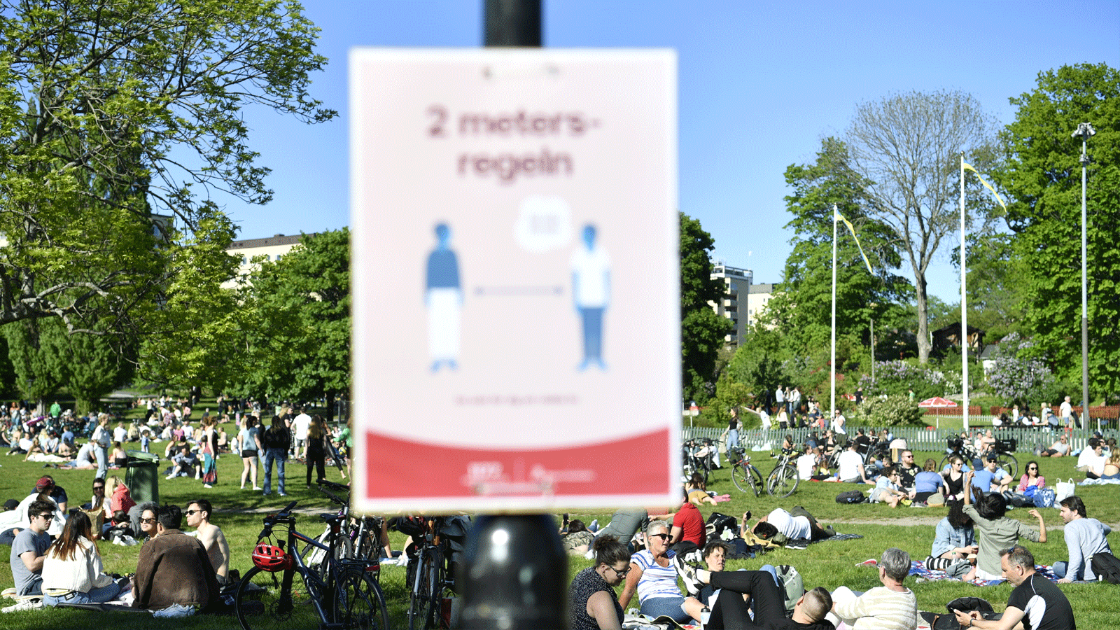 لافتة في منتزه تطالب الناس بالتباعد الاجتماعي في السويد