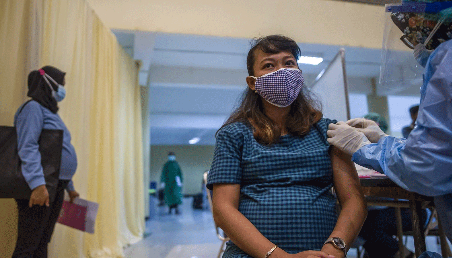  امرأة حامل تتلقى لقاح Sinovac ضد فيروس كورونا Covid-19 في سورابايا. في 19 أغسطس 2021، خلال برنامج تطعيم سريع يشمل النساء الحوامل