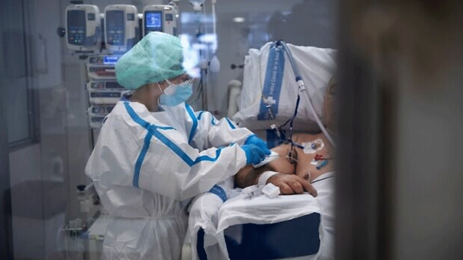 عامل رعاية صحية يعتني بمريض كوفيد -19، في وحدة العناية المركزة (ICU) في مستشفى جامعة بيلفيج في برشلونة في 19 كانون الثاني\يناير 2022