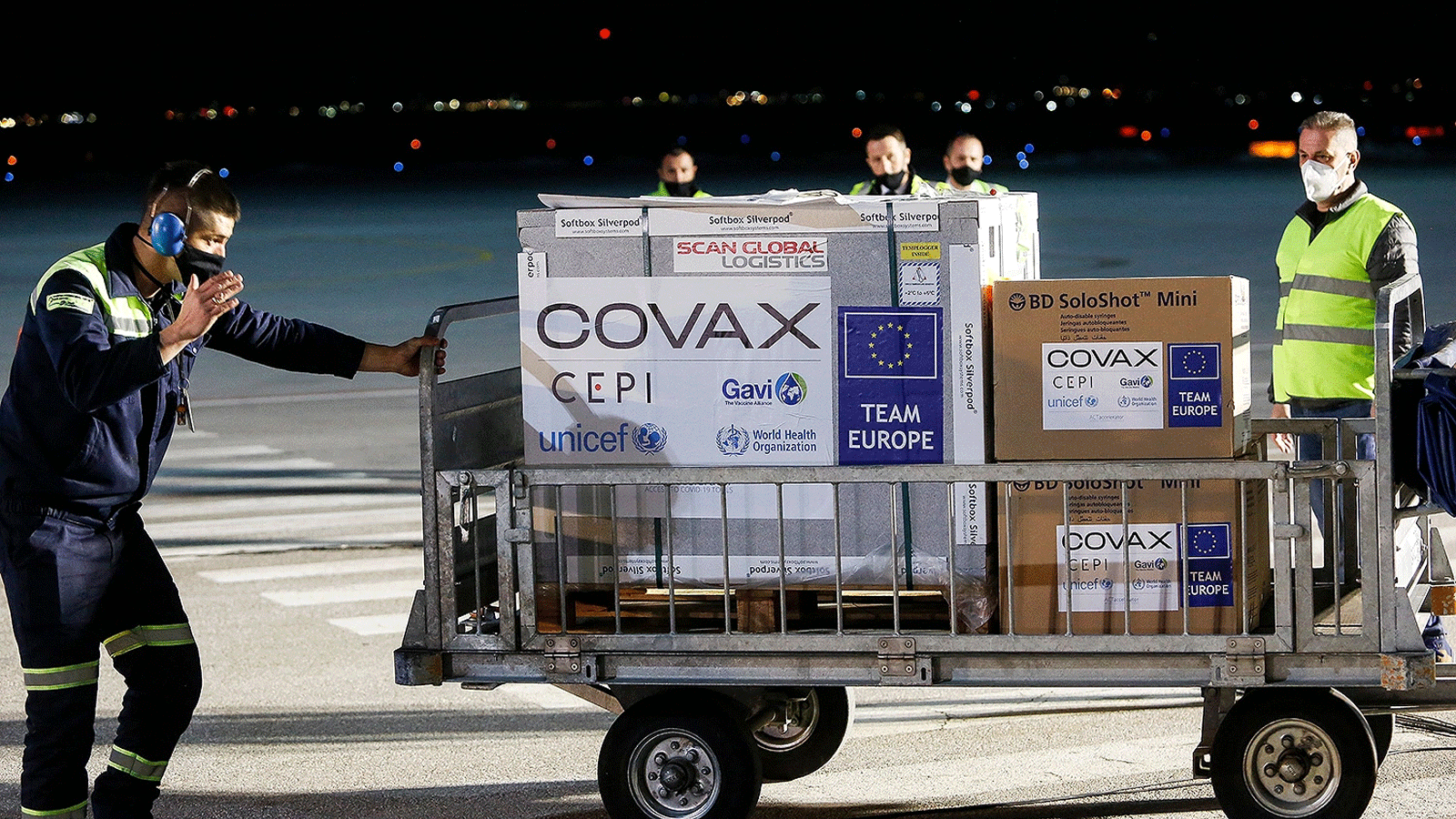  موظفو المطار يدفعون عربة تحمل الشحنة الأولى من جرعات التطعيم COVID-19 في مطار بريشتينا الدولي في بريشتينا، كوسوفو، في 28 آذار\مارس 2022
