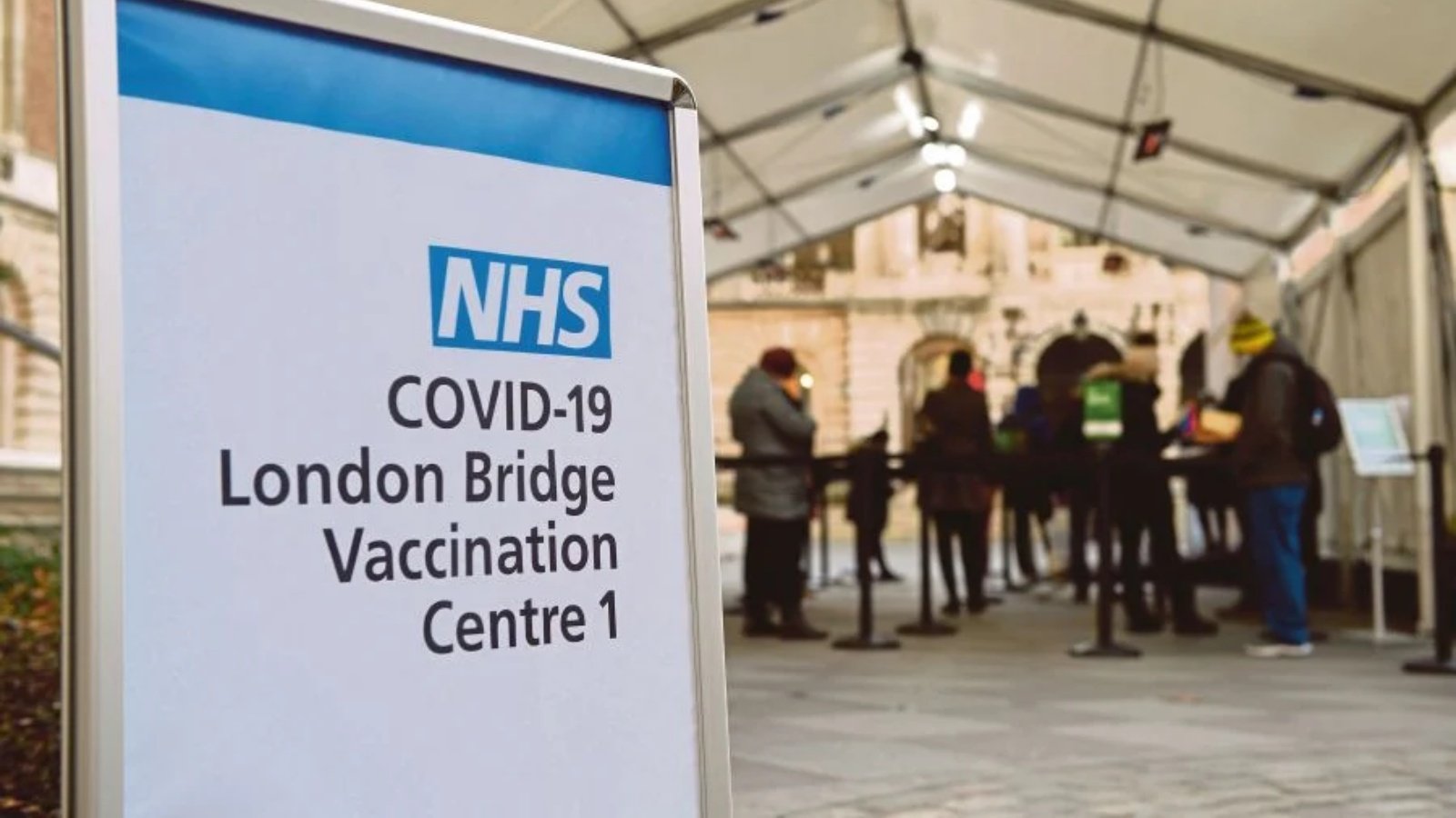 الناس يقفون في طابور في مركز تطعيم NHS للقاح كوفيد-19 فايزر بيونتك في لندن