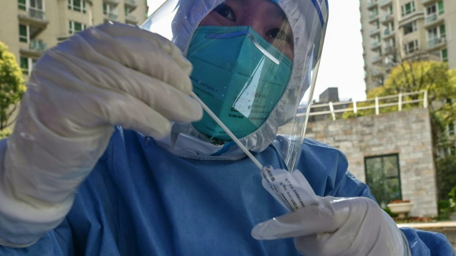 عامل طبي يستعد لإجراء فحص لكشف الإصابة بكوفيد-19 في مجمع سكني في شانغهاي في الأول من أبريل 2022