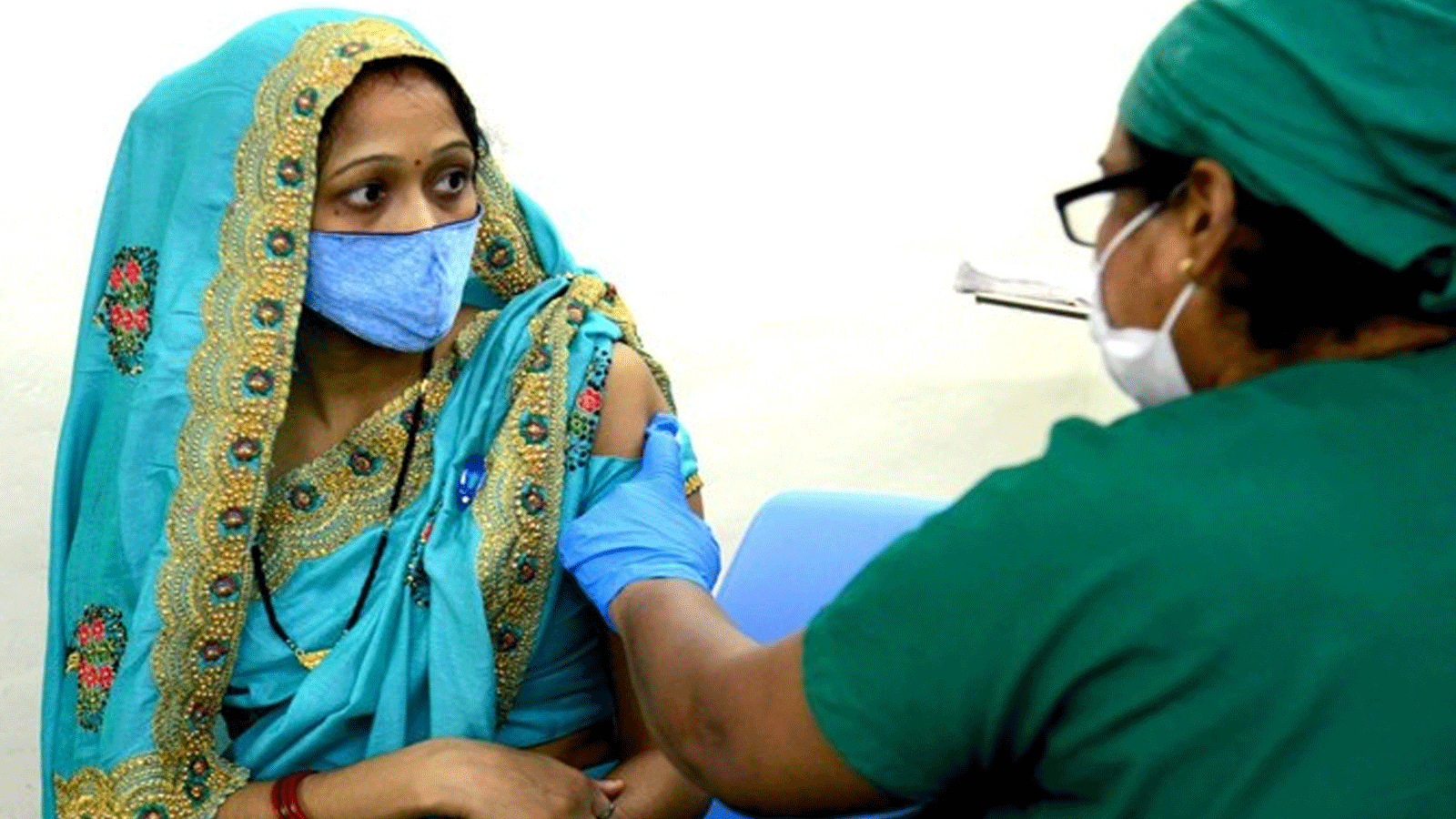 عاملة صحية تقوم بتلقيح امرأة بجرعة من لقاح فيروس كورونا Covid-19 في مستشفى ناير في مومباي.