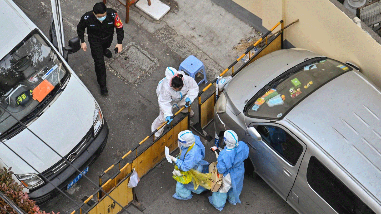 عمال الصحة، يرتدون معدات الحماية الشخصية (PPE)، يقفون عند نقطة تفتيش بجوار أحد الأحياء خلال إغلاق COVID-19 في منطقة جينغان في شنغهاي في 8 نيسان\ أبريل 2022.