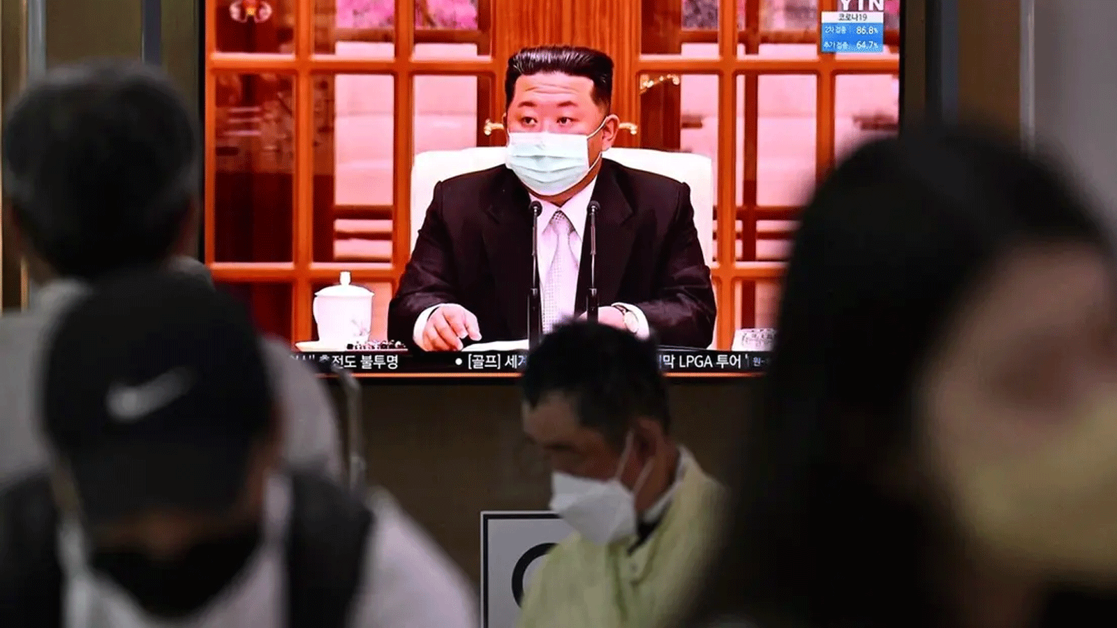 أشخاص يجلسون بالقرب من شاشة تعرض نشرة إخبارية في محطة قطار في سيول في 12 أيار\مايو 2022. زعيم كوريا الشمالية كيم جونغ أون يظهر مرتديًا قناع وجه على شاشة التلفزيون لأول مرة، ليأمر بإغلاق جميع أنحاء البلاد
