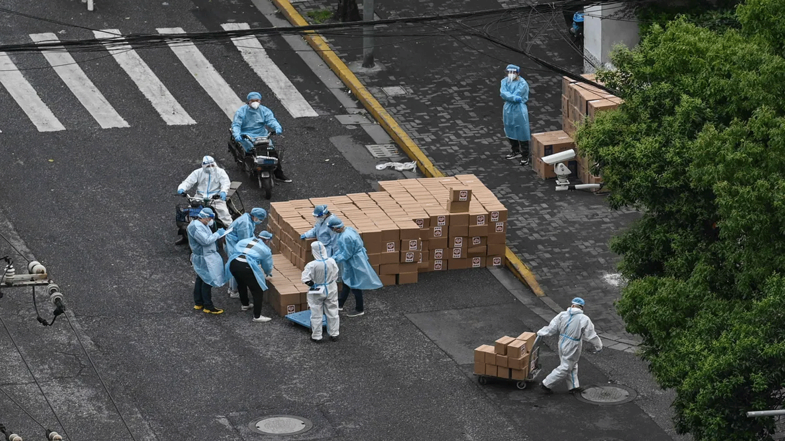  تقوم معدات الحماية الشخصية aring بسحب عربة تحمل صناديق في أحد الشوارع أثناء فترة الإغلاق جراء فيروس كورونا Covid-19 في منطقة Jing'an في شنغهاي في 13 أيار\مايو 2022.