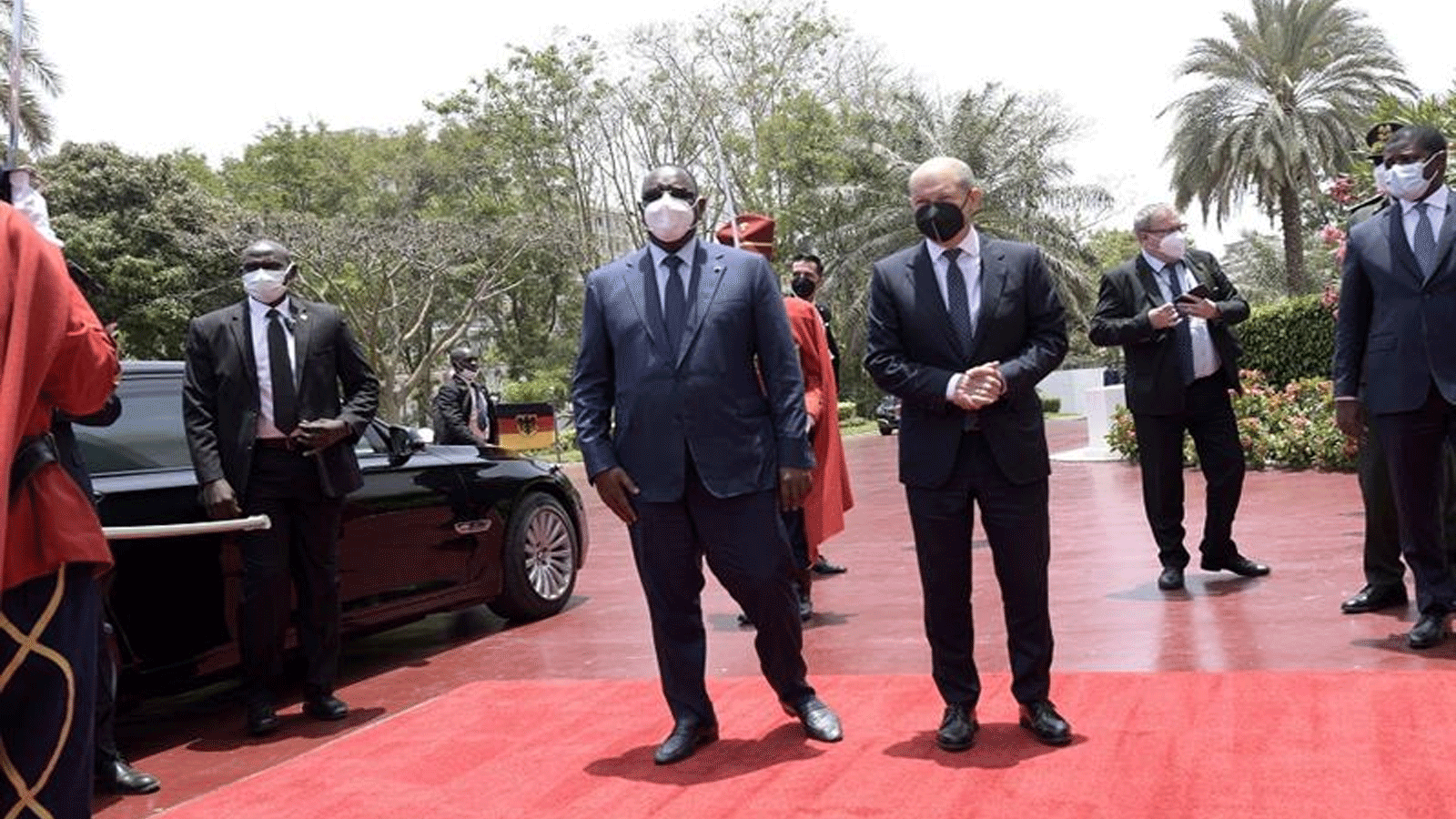 الرئيس السنغالي ماكي سال (يسار) يسير مع المستشار الألماني أولاف شولتز (يمين) في قصر جمهورية السنغال في 22 أيار\مايو 2022