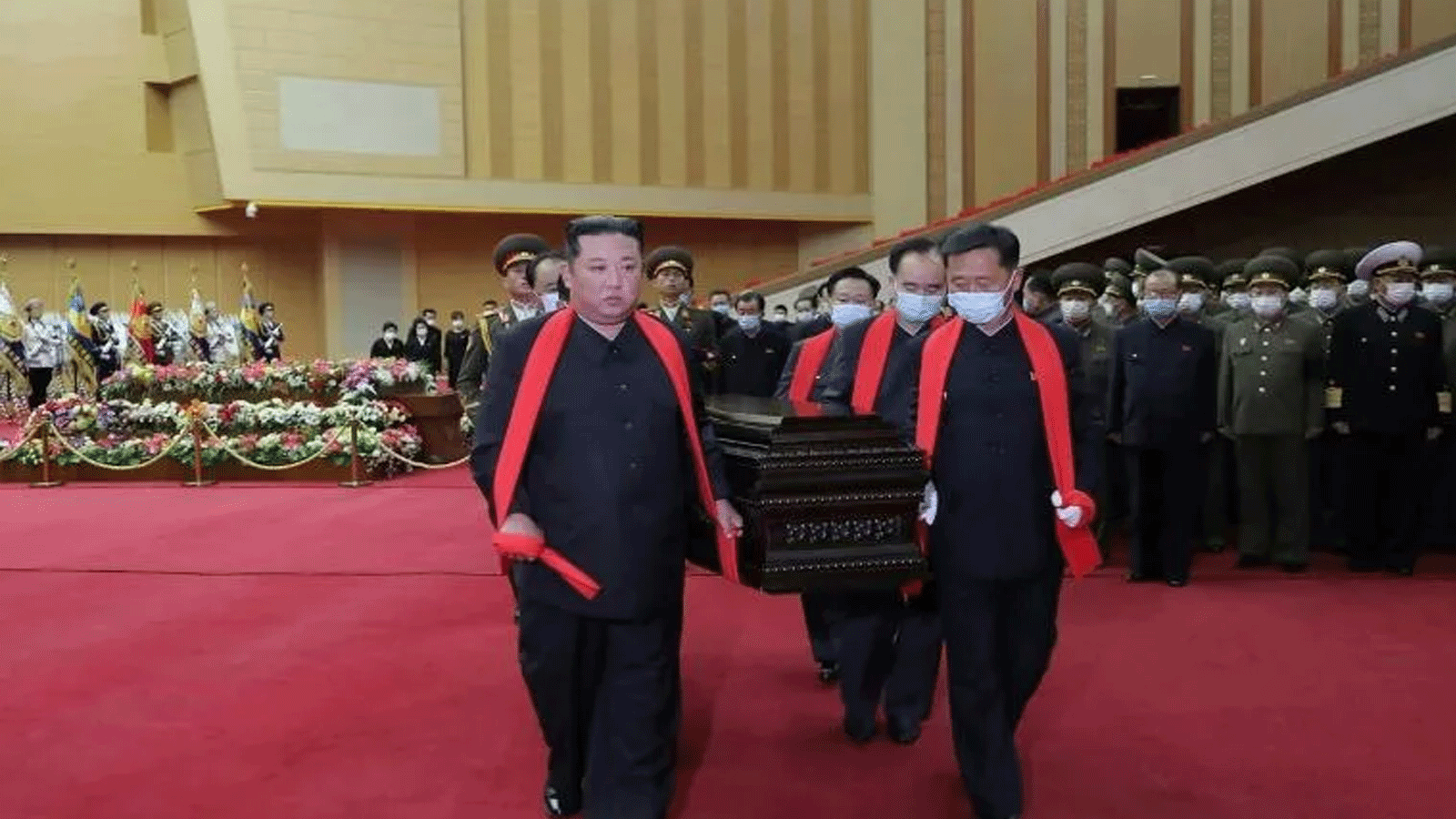 زعيم كوريا الشمالية كيم جونغ-أون جنازة يحمل نعش "معلمه" الضابط العسكري الكبير دون أن يضع كمامة 