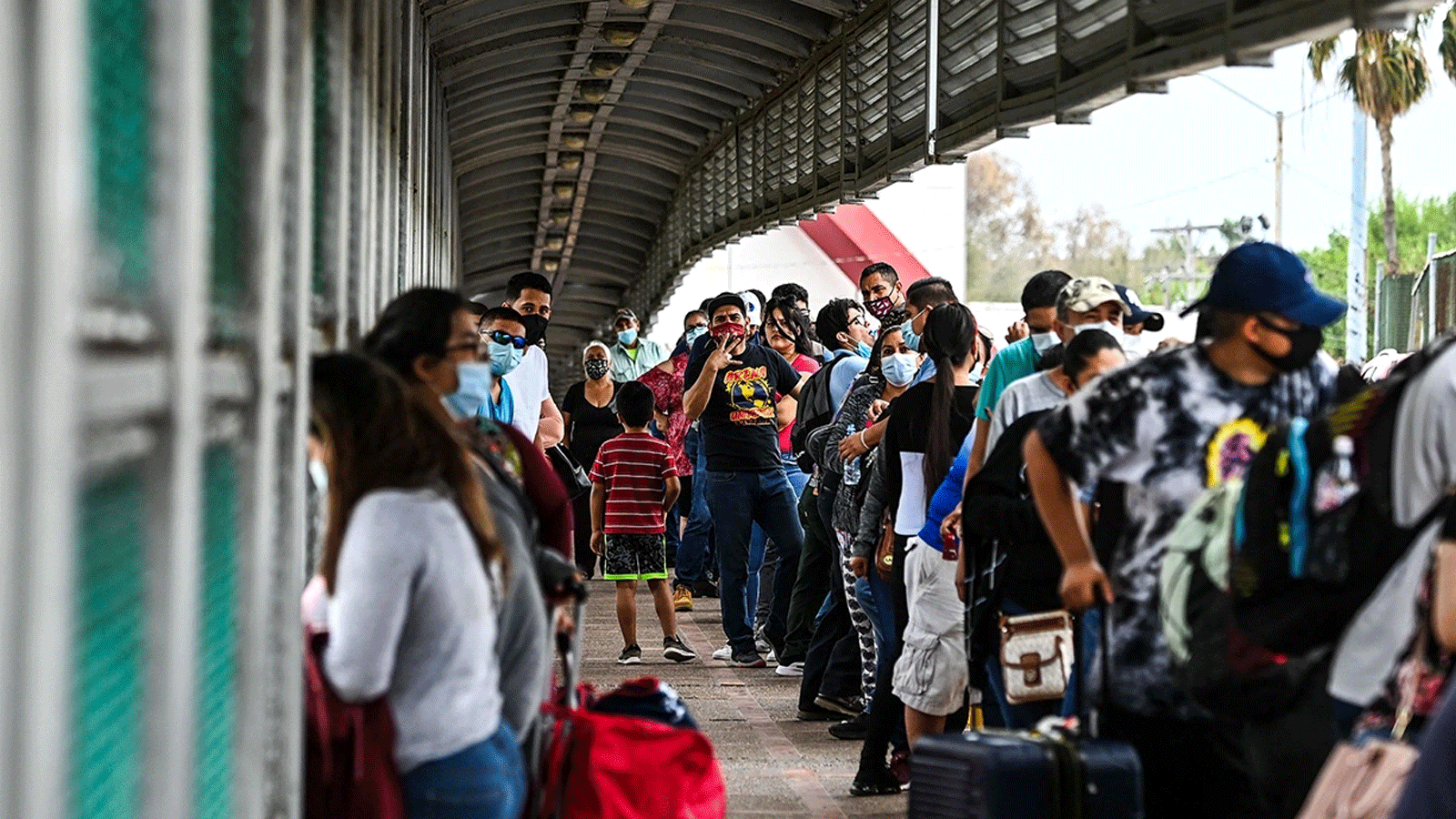 مهاجرون ينتظرون عبور الحدود عند جسر جيتواي الدولي من ماتاموروس، المكسيك، إلى براونزفيل، تكساس، في 15 آذار\مارس 2021