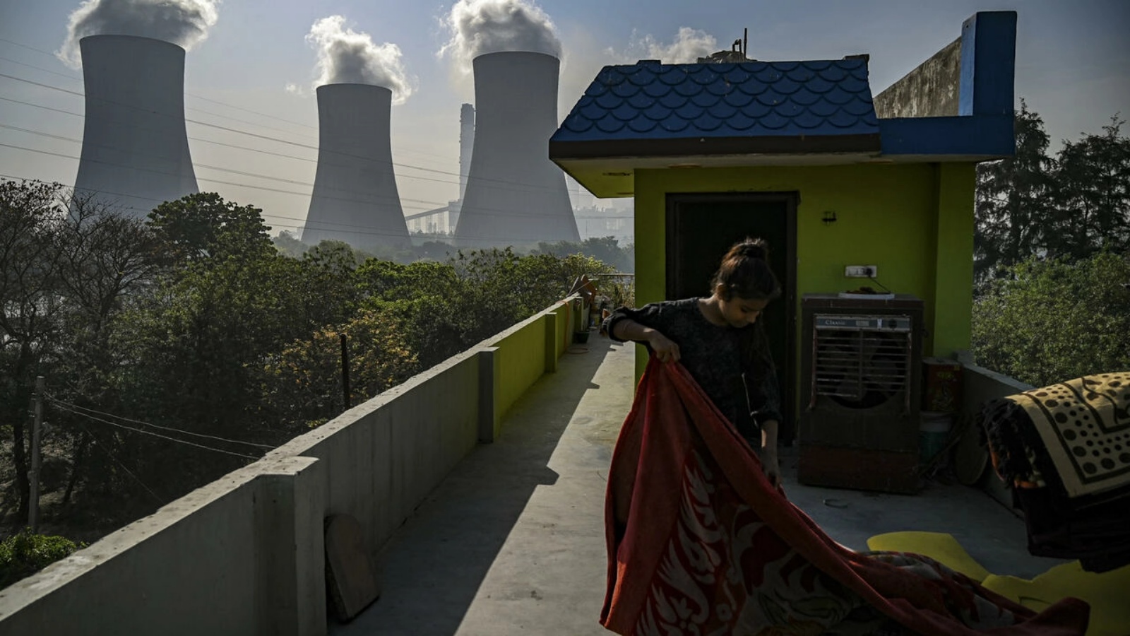 فتاة تقف بالقرب من محطة كهرباء في دادري في الهند - تقول وكالة المناخ الأمريكية الرئيسية إن مستويات ثاني أكسيد الكربون في الغلاف الجوي وصلت إلى أعلى مستوى لها منذ أربعة ملايين عام