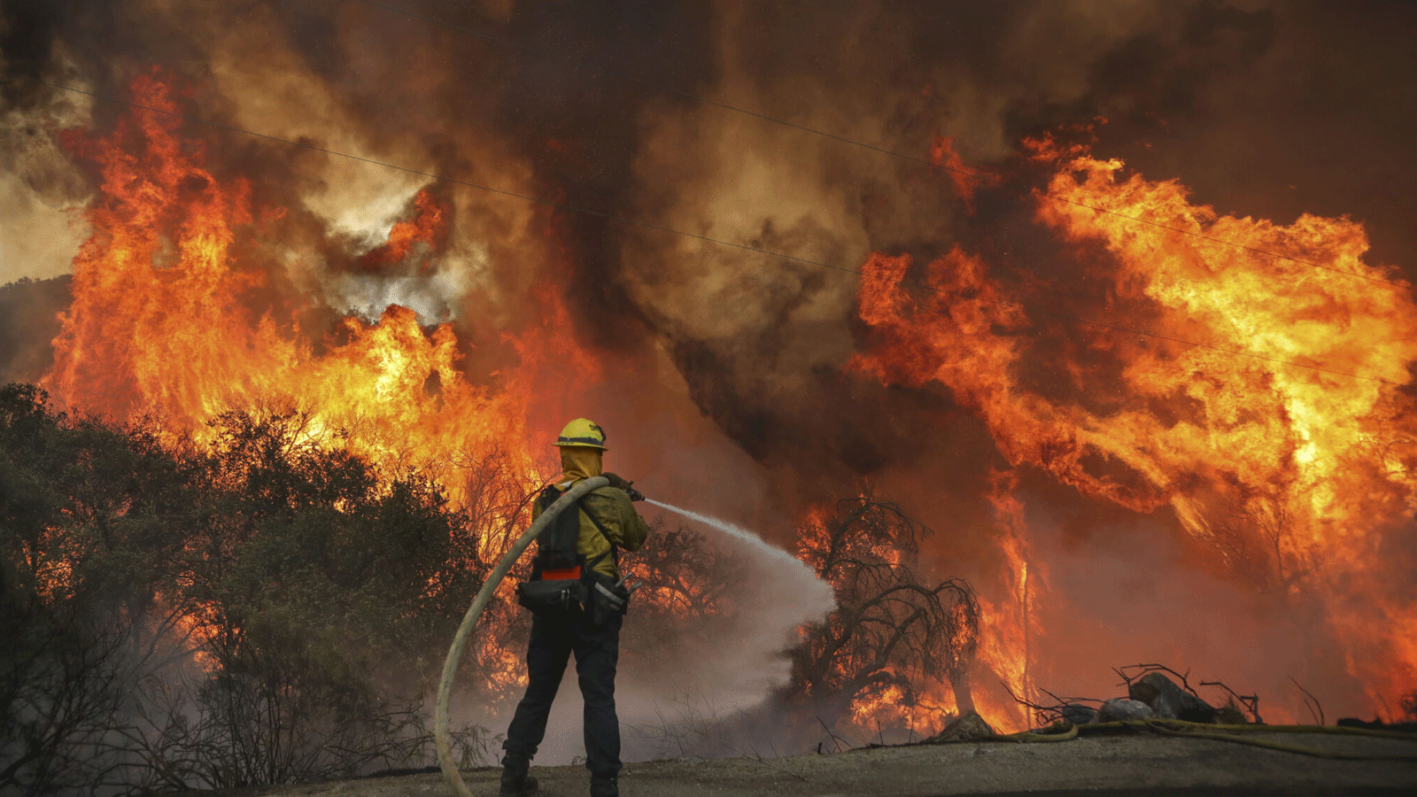 رجال الإطفاء في مقاطعة سان ميغيل يكافحون حريقًا على طول طريق جاباتول أثناء حريق الوادي في جامول، كاليفورنيا. 6 أيلول\سبتمبر 2020