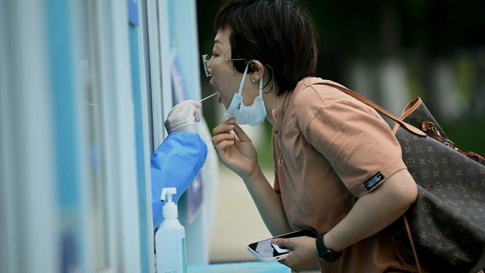 عاملة في المجال الصحي تجري فحص الكشف عن الإصابة بكوفيد-19 لإمرأة في بكين في 19 يونيو 2022