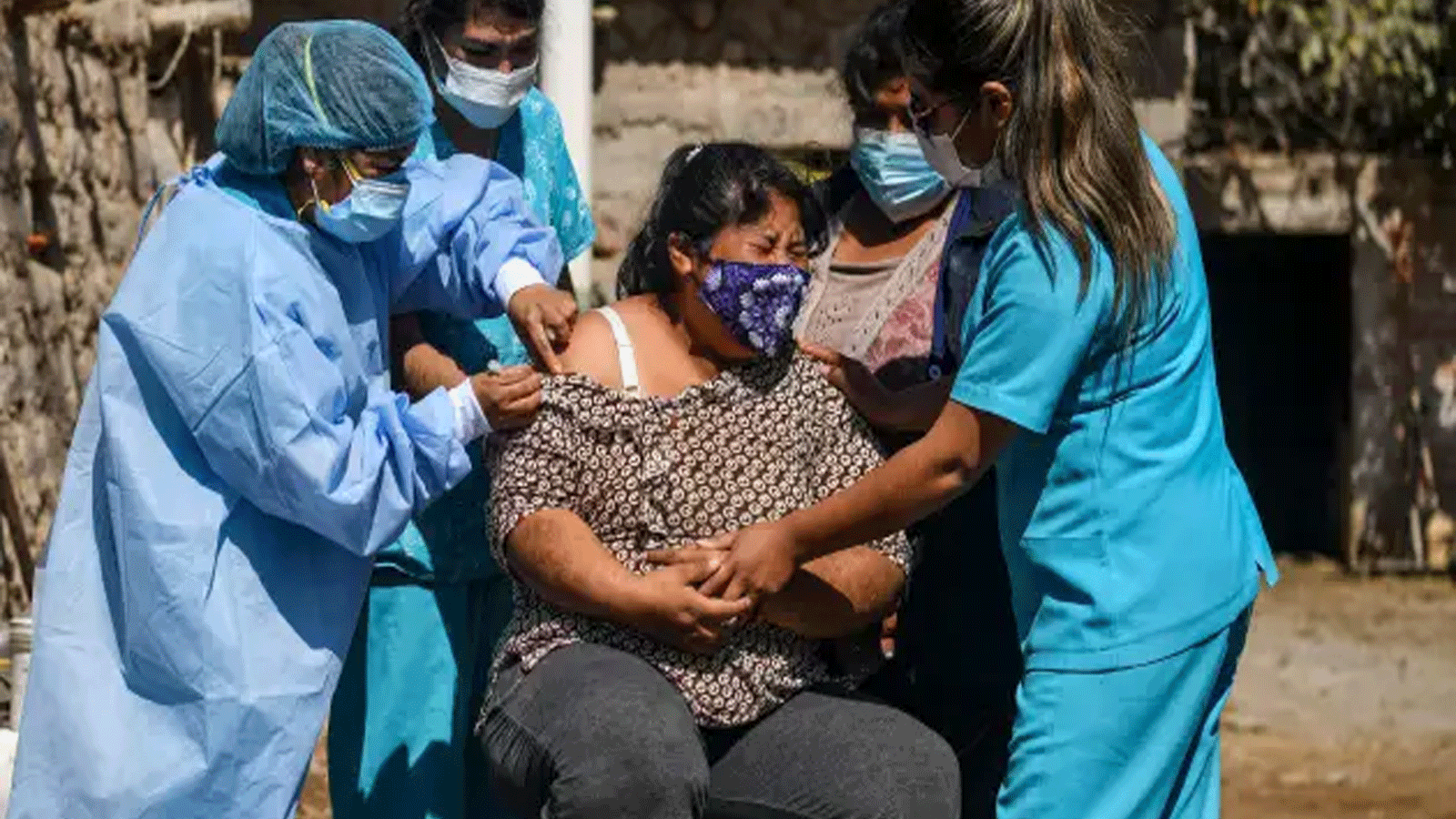 عاملون في مجال الصحة يقومون بتلقيح امرأة في البيرو