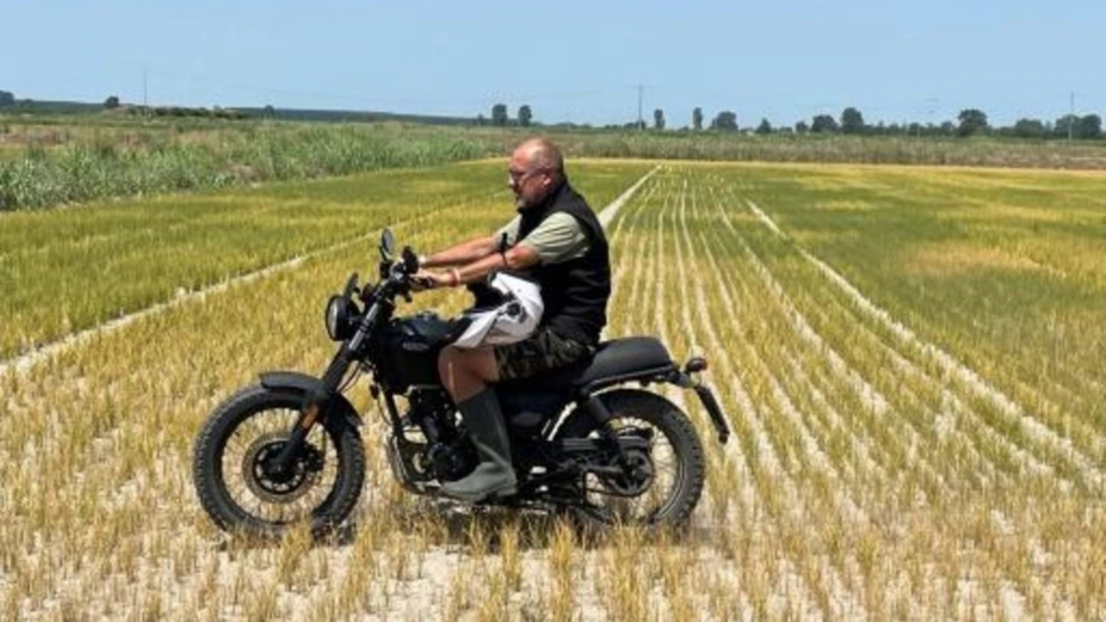 مزراع الأرز داريو فيتسيني يعبر بدارجته النارية أحد حقوله في زيمي في 18 يوليو 2022 
