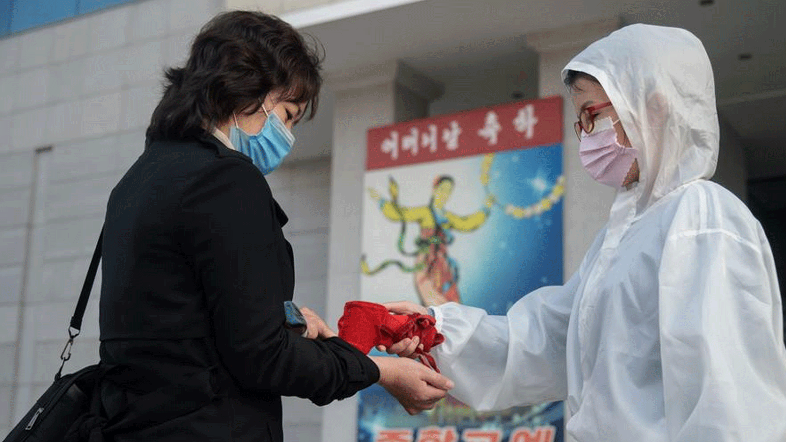 عاملة صحة تقيس الحرارة لمريضة في كوريا الشمالية